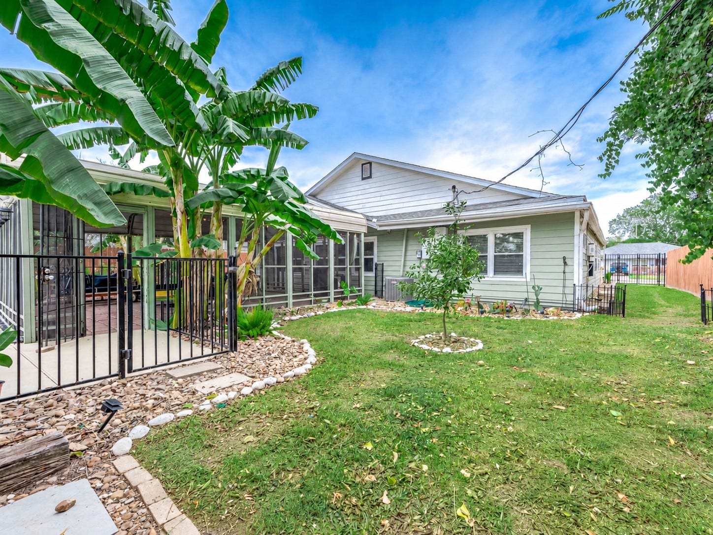 115 S Yaupon Street, Lake Jackson, TX 77566 Backyard with metal pool fencing and open grass area.