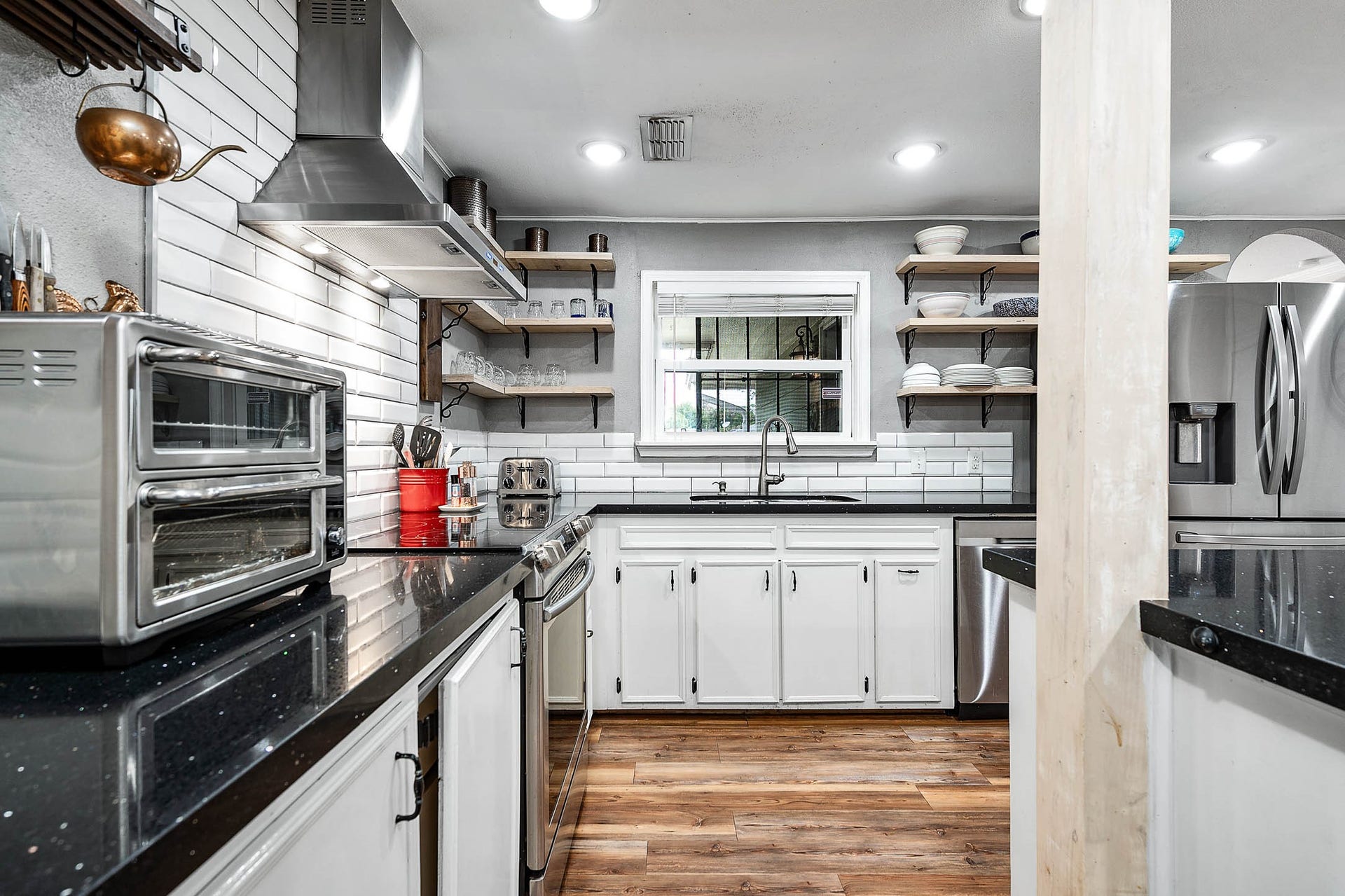 115 S Yaupon Street, Lake Jackson, TX 77566 Slide-in electric range with stainless vent hood and subway tile backsplash.