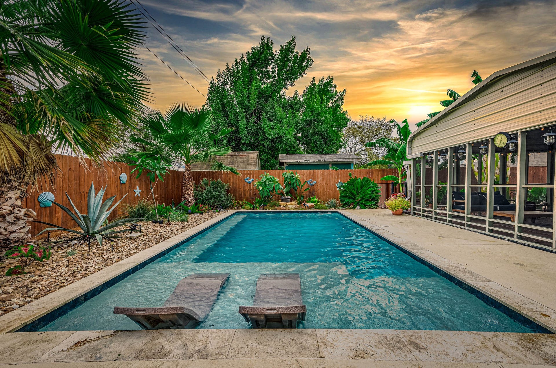 115 S Yaupon Street, Lake Jackson, TX 77566 In-ground gunite pool with tanning ledge, surrounded by lush tropical landscaping.