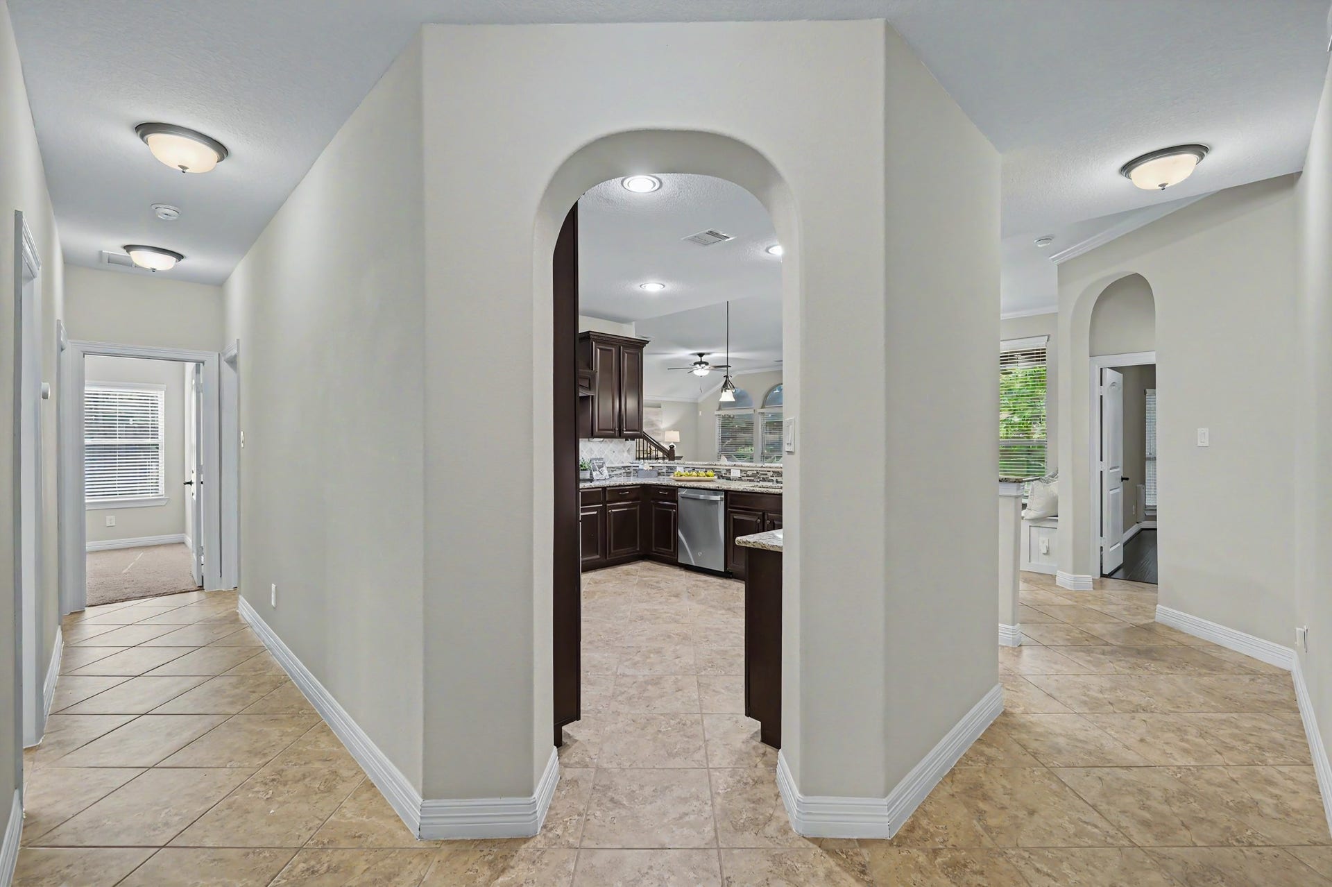 Down the foyer, left is to the secondary bedrooms & 2 baths, right is to the primary and family room, and thru the arch leads to a gorgeous kitchen