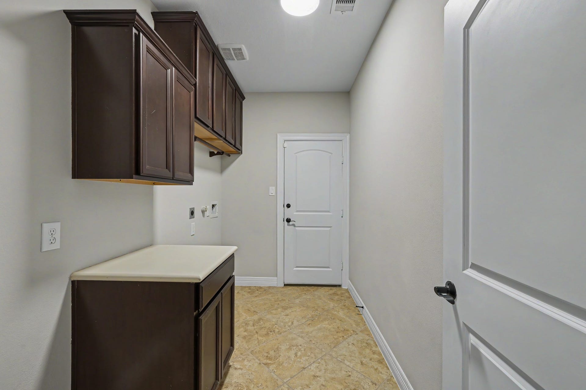 First floor, in home utility room off of garage. Electric & gas hookups and room for extra refrigerator