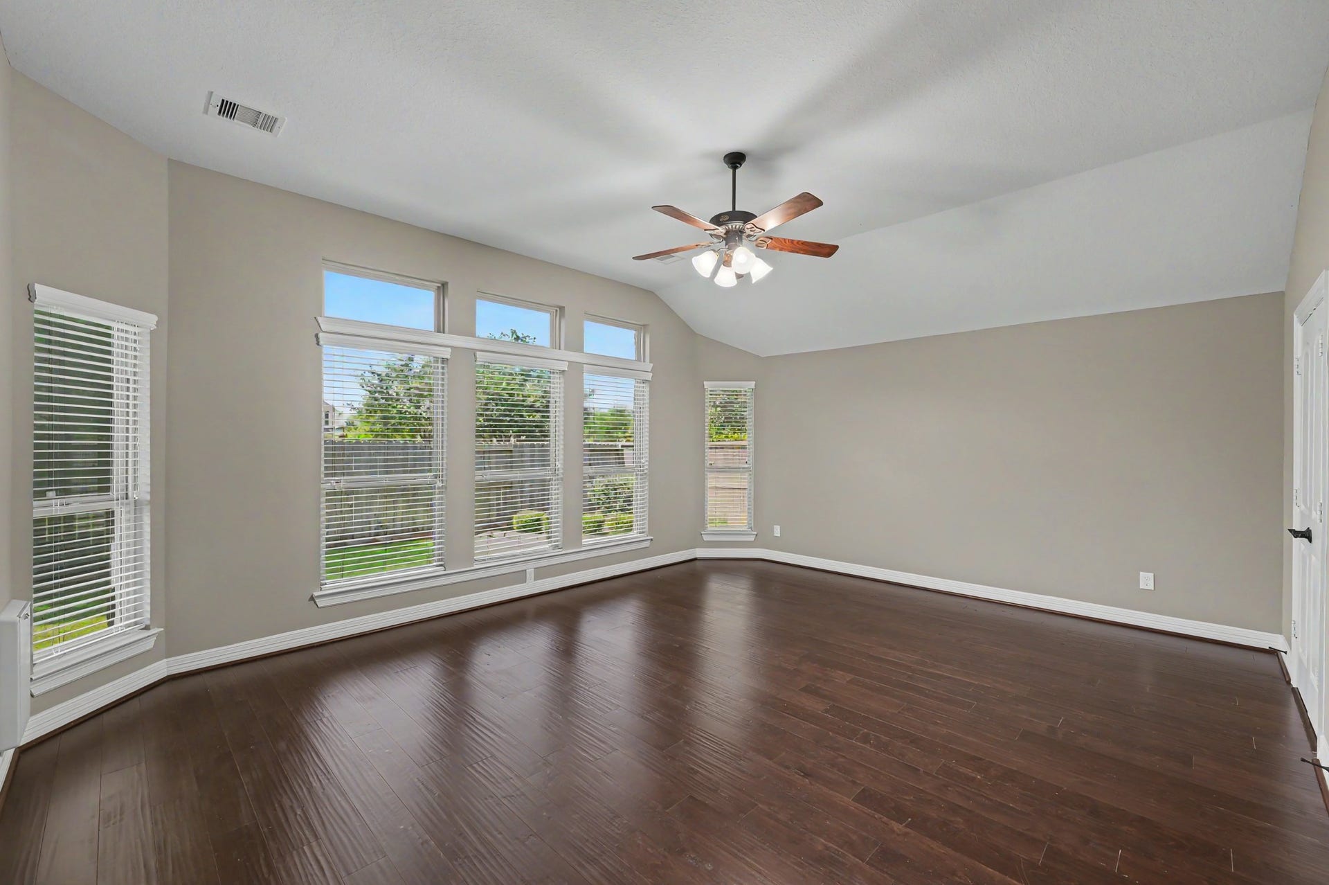 Expansive primary bedroom, 19x15, rich hardwood floors, abundant natural light.