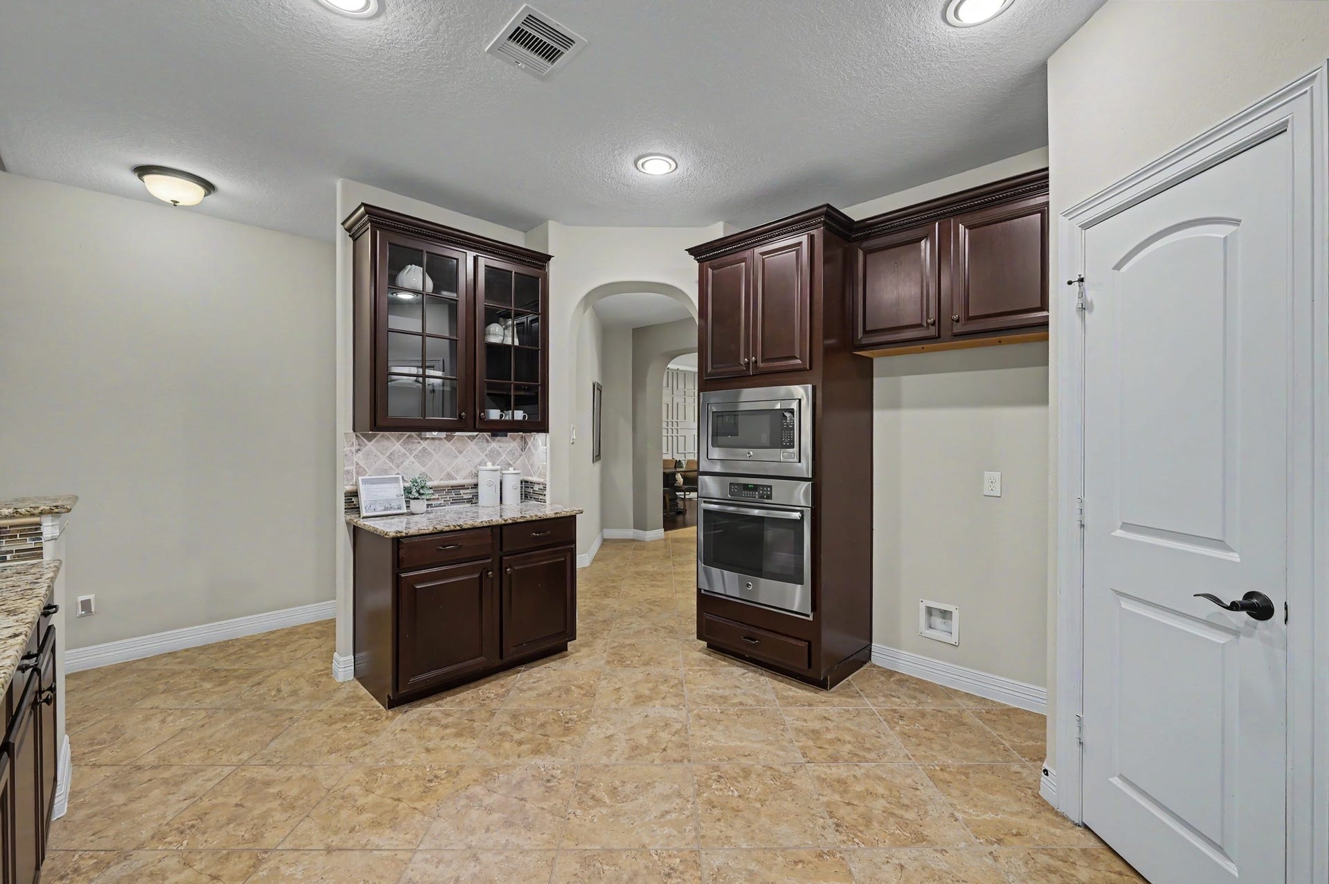 Walk in pantry with floor to ceiling built in spice storage, under cabinet lights, and additional outlets throughout the kitchen