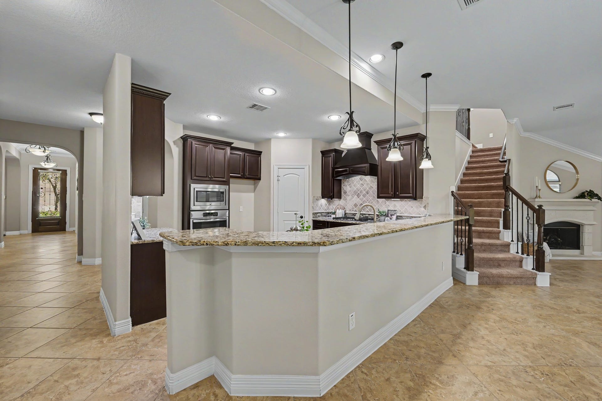 Spacious kitchen with a large breakfast bar, pendant lighting, and an open connection to the living area.