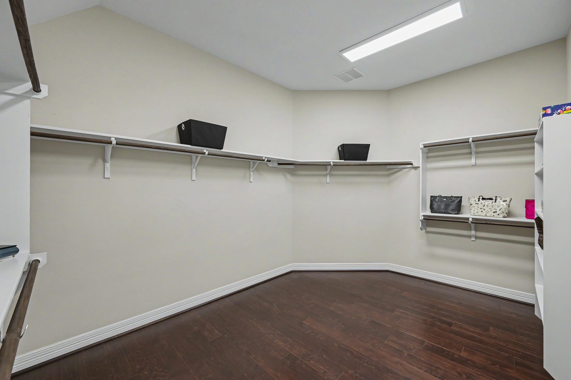 Room sized primary walk in closet, built in shelving plus hanging racks. Well beyond standard closet size