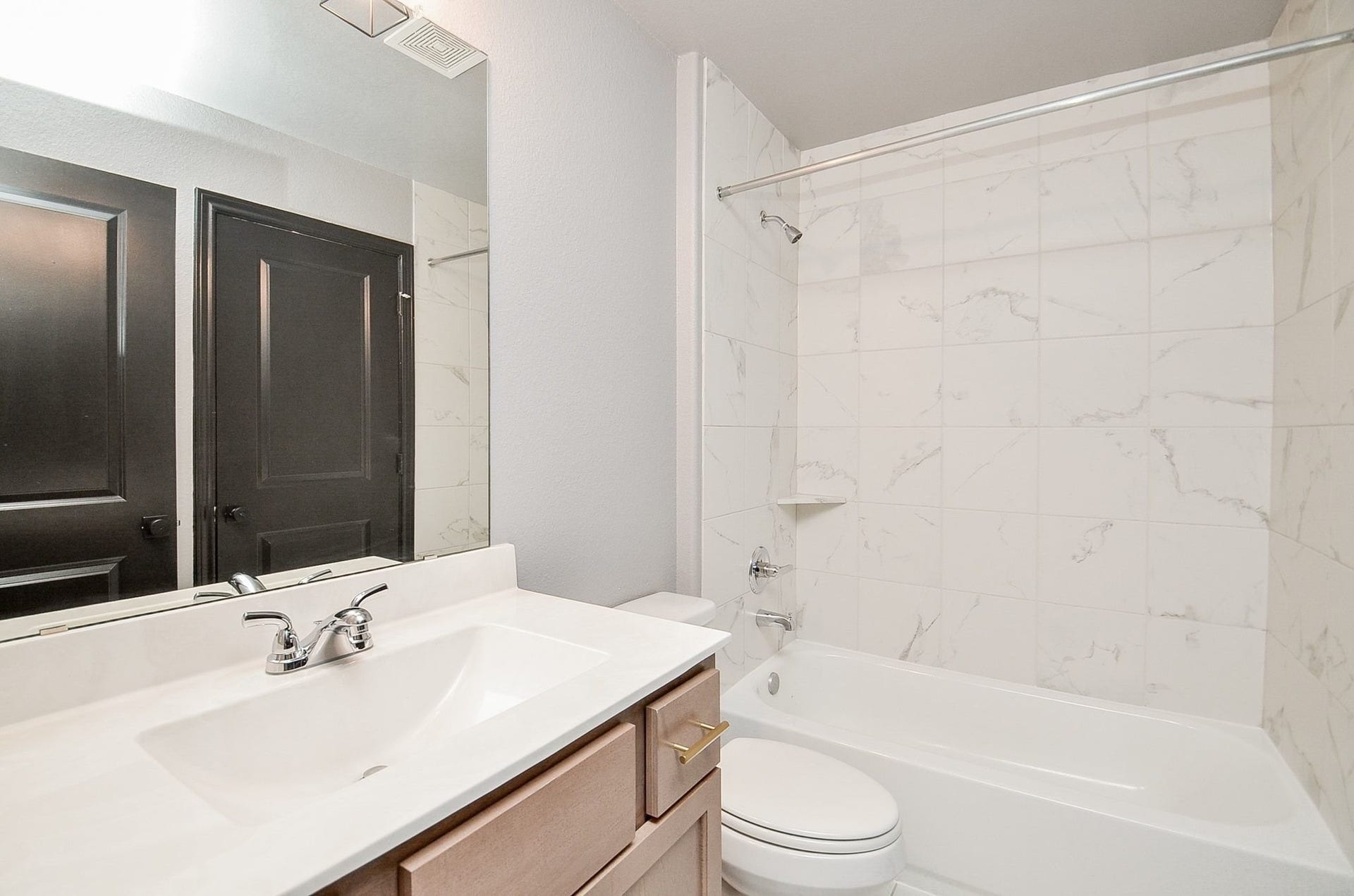 860 Marisol Bay Drive, Katy, TX 77493 This modern bathroom features marble tile, a sleek vanity with ample counter space, and a pristine bathtub-shower combo. It is shared with a private bedroom entrance and the gameroom.