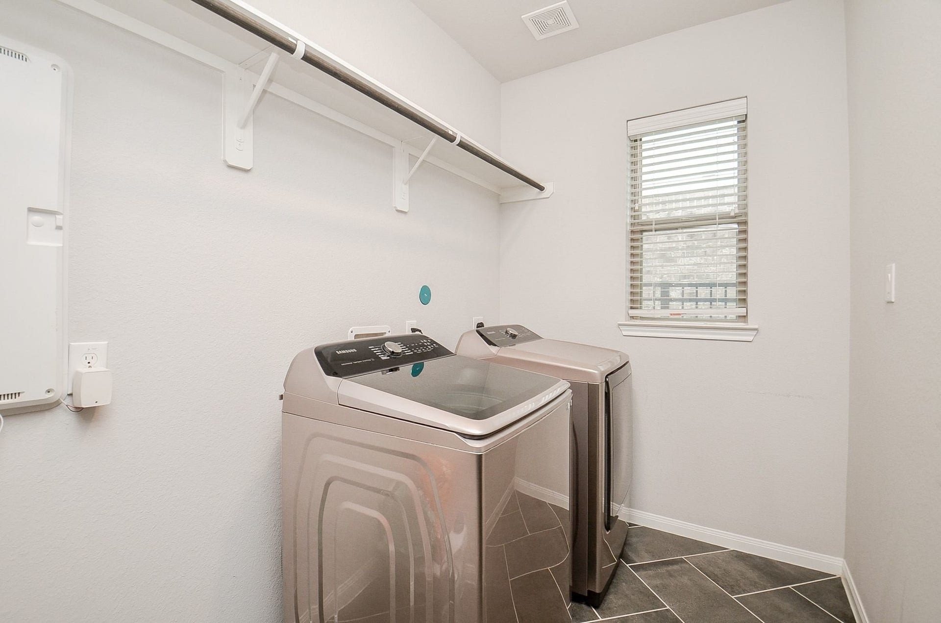 860 Marisol Bay Drive, Katy, TX 77493 Modern laundry room featuring sleek appliances, tiled flooring, and ample shelving for storage.