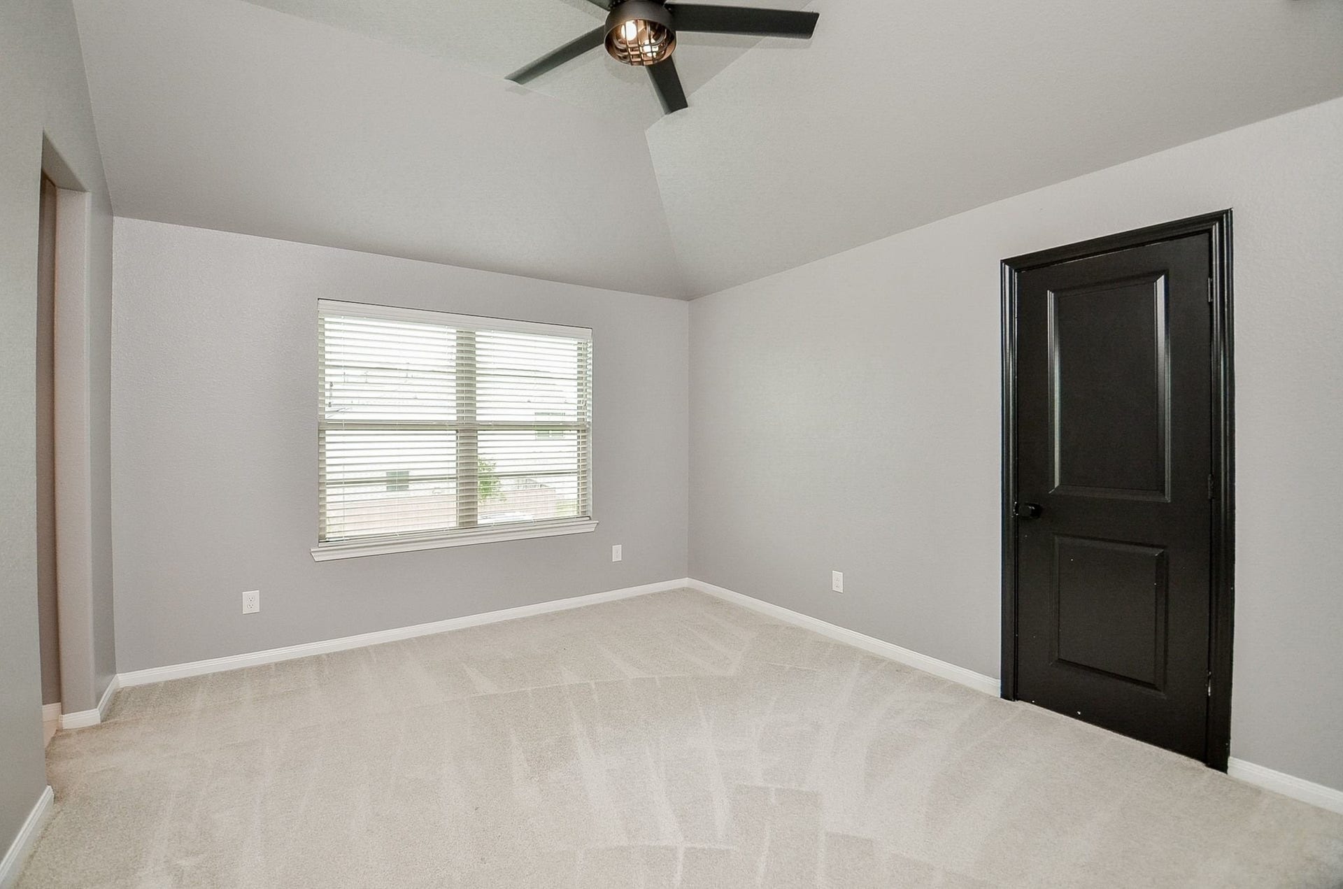 860 Marisol Bay Drive, Katy, TX 77493 Immediately to the right at the top of the stairs is this spacious bedroom with soft carpet flooring, a modern ceiling fan, and ample natural light from a large window. This room also has a private ensuite bathroom and walk in closet
