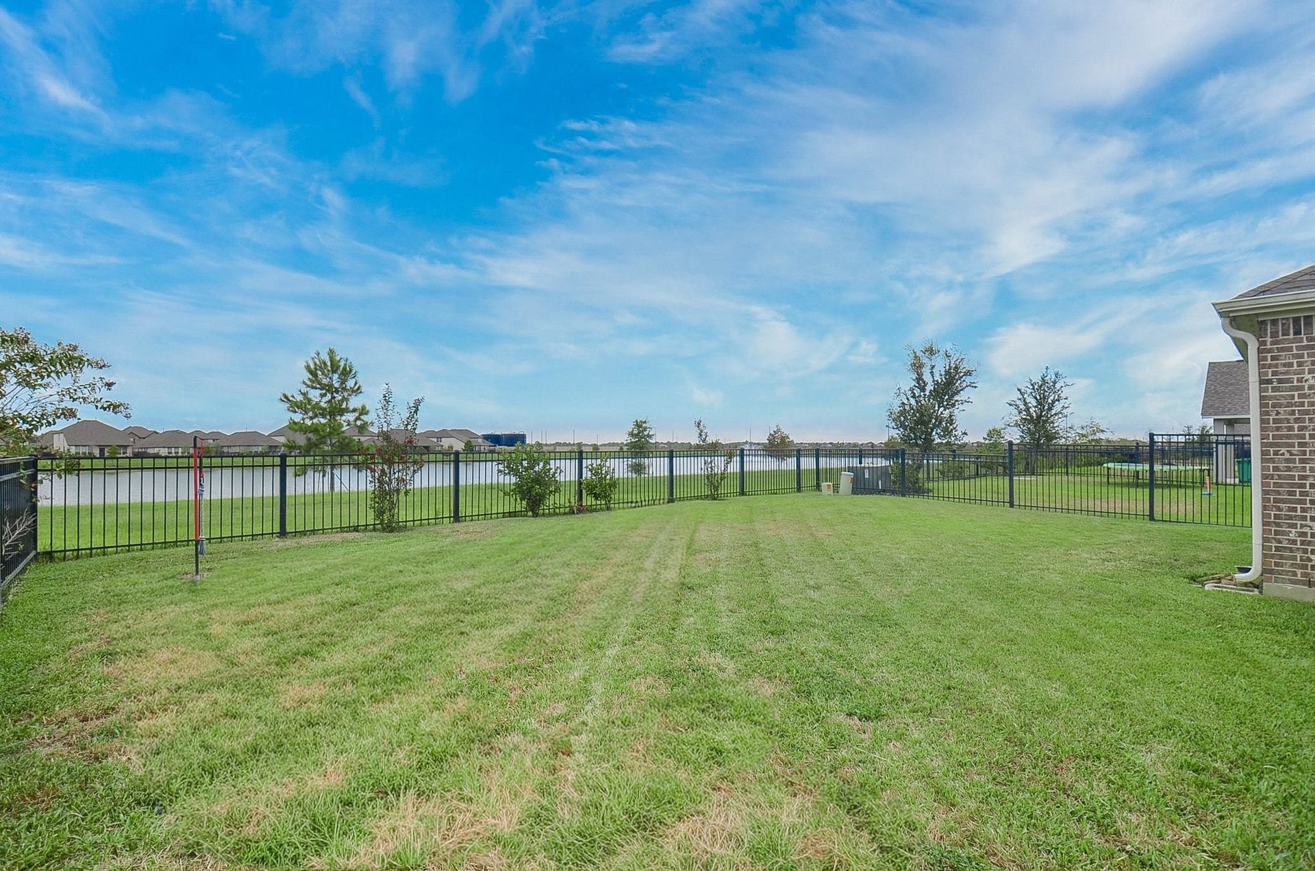 860 Marisol Bay Drive, Katy, TX 77493 Expansive backyard with well-maintained lawn, enclosed by a secure fence, offering picturesque water views for a serene and private outdoor experience.