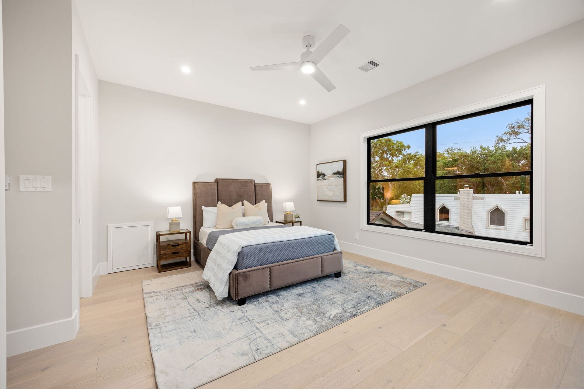 14106 Heatherfield Drive, Houston, TX 77079 This serene bedroom offers a calming retreat with soft tones, warm wood flooring, and an open layout that feels both spacious and inviting. Large windows flood the room with natural light and provide peaceful views. The highlight of this room is the expansive picture window, bringing the outdoors in while creating a bright, tranquil atmosphere ideal for rest and relaxation.
