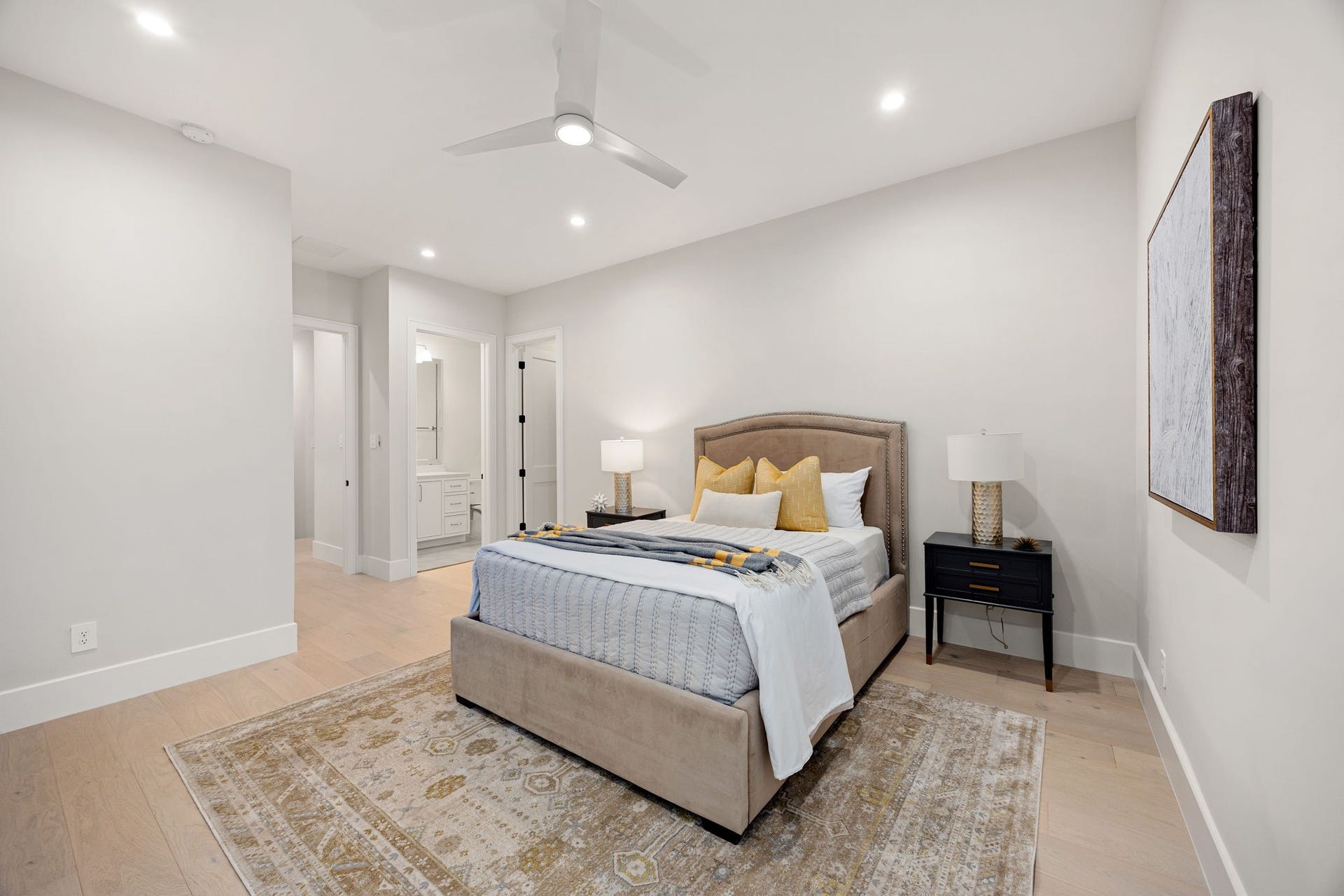 14106 Heatherfield Drive, Houston, TX 77079 A spacious and serene bedroom retreat designed with comfort in mind, featuring soft neutral tones, warm wood flooring, and a cozy layout. The room flows effortlessly into the ensuite bath for added convenience. The highlight of this space is the private ensuite access, offering a seamless connection to a beautifully appointed bathroom for everyday ease and comfort.