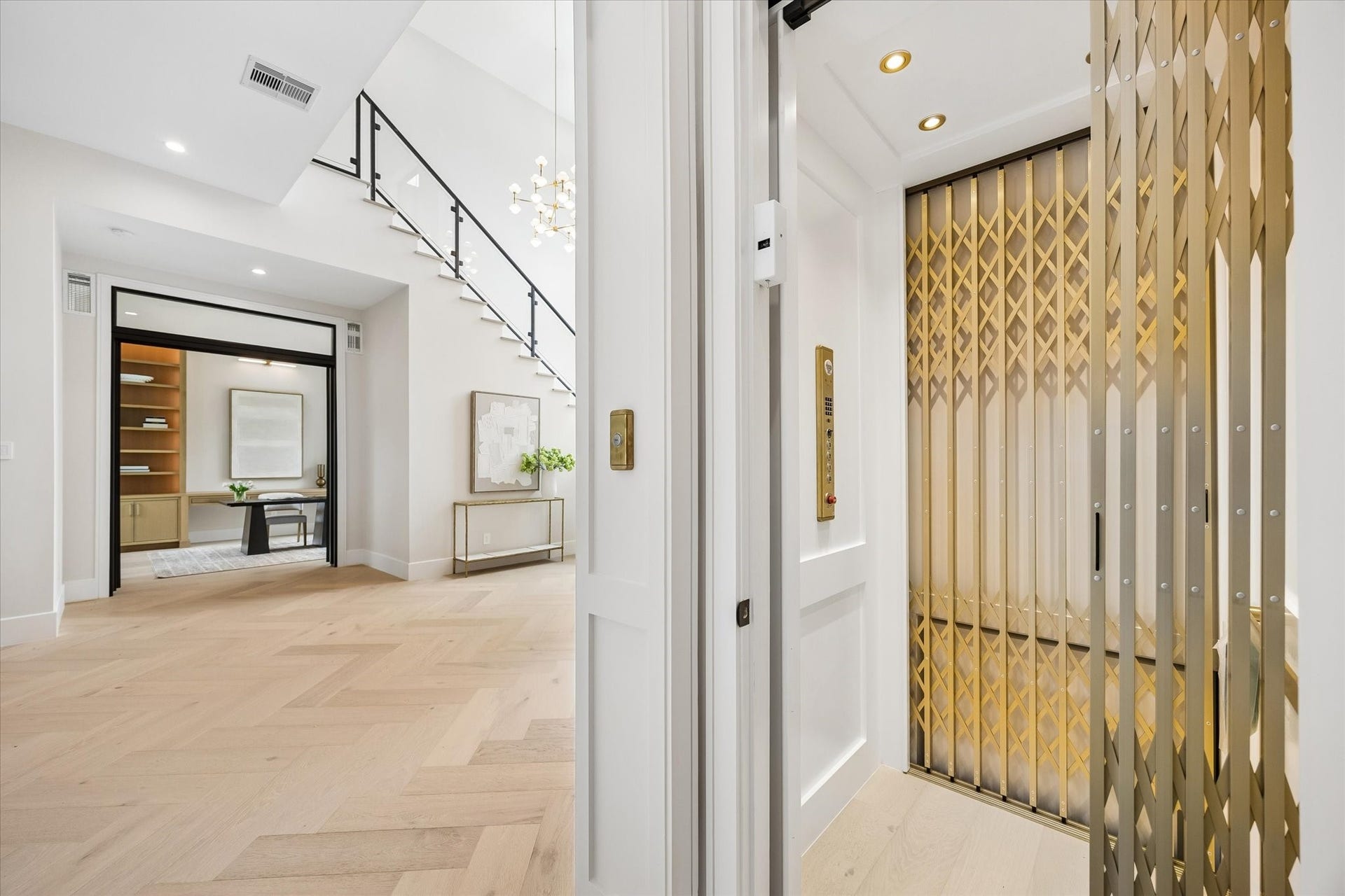 14106 Heatherfield Drive, Houston, TX 77079 A private residential elevator adds exceptional convenience while complementing the homes refined design. The elegant brass-toned accordion gate and coordinating controls introduce a distinctive architectural detail, while the surrounding hall showcases wide-plank flooring, crisp millwork and a modern stair railing. With the handsome home office visible beyond, this thoughtfully designed transition space reflects the craftsmanship and elevated functionality found throughout the residence.