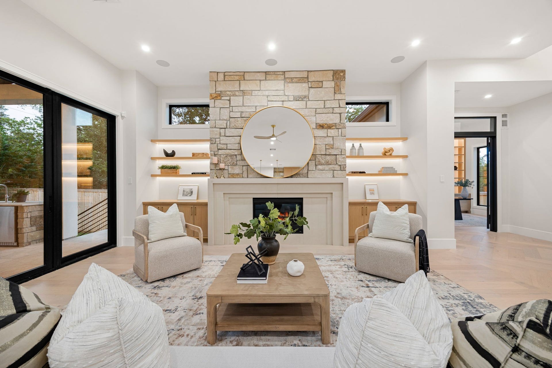 14106 Heatherfield Drive, Houston, TX 77079 A perfectly balanced view of the central fireplace wall, where clean symmetry meets natural texture. The stone surround, custom cabinetry, and softly lit shelving create a layered, cohesive look that draws the eye. Subtle detailing and warm finishes add depth without overwhelming the space, resulting in a refined focal point that anchors the entire living area.