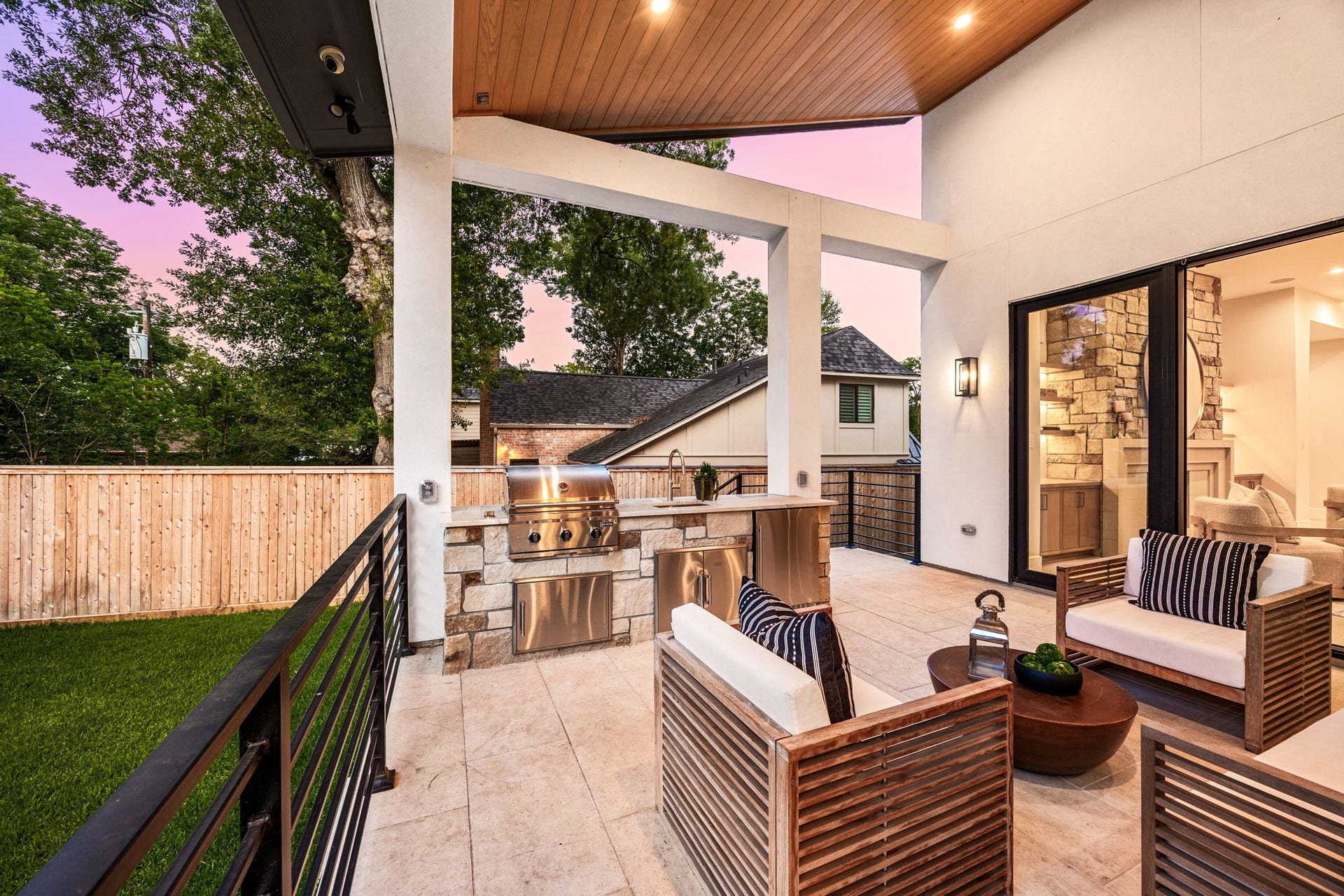 14106 Heatherfield Drive, Houston, TX 77079 This inviting outdoor entertaining space combines modern design with functional luxury, featuring comfortable seating and a seamless flow to the backyard. The covered structure adds comfort while maintaining openness. The highlight of this space is the built-in grill and outdoor kitchen, creating the ultimate setup for entertaining guests and enjoying outdoor living at its finest.