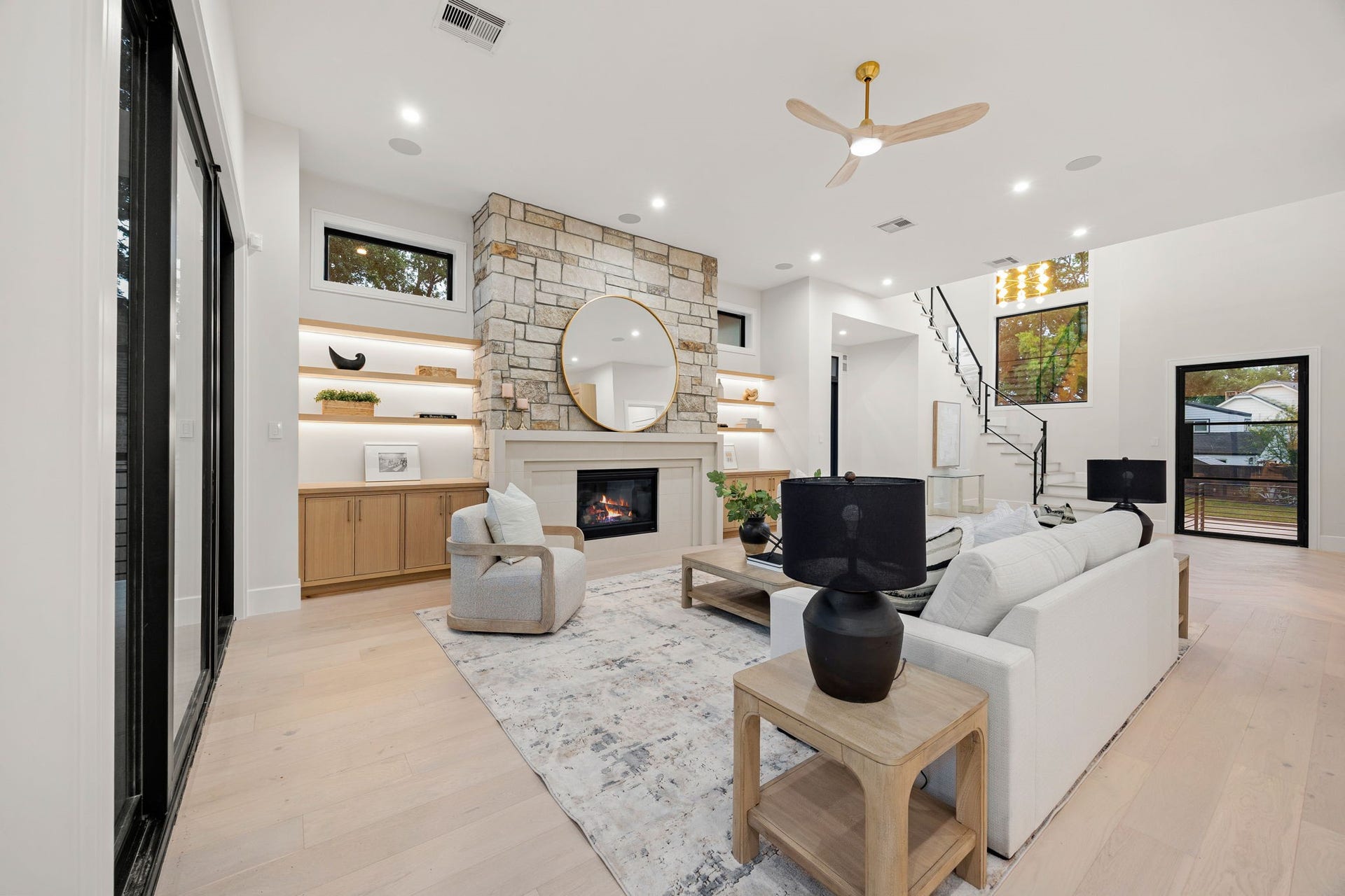 14106 Heatherfield Drive, Houston, TX 77079 A spacious living area designed with both scale and comfort in mind, offering multiple seating options and clear views across the open floor plan. High ceilings and recessed lighting enhance the sense of openness, while large windows bring in consistent natural light. The layout encourages connection while still allowing for defined spaces, making it ideal for both quiet evenings and lively gatherings.