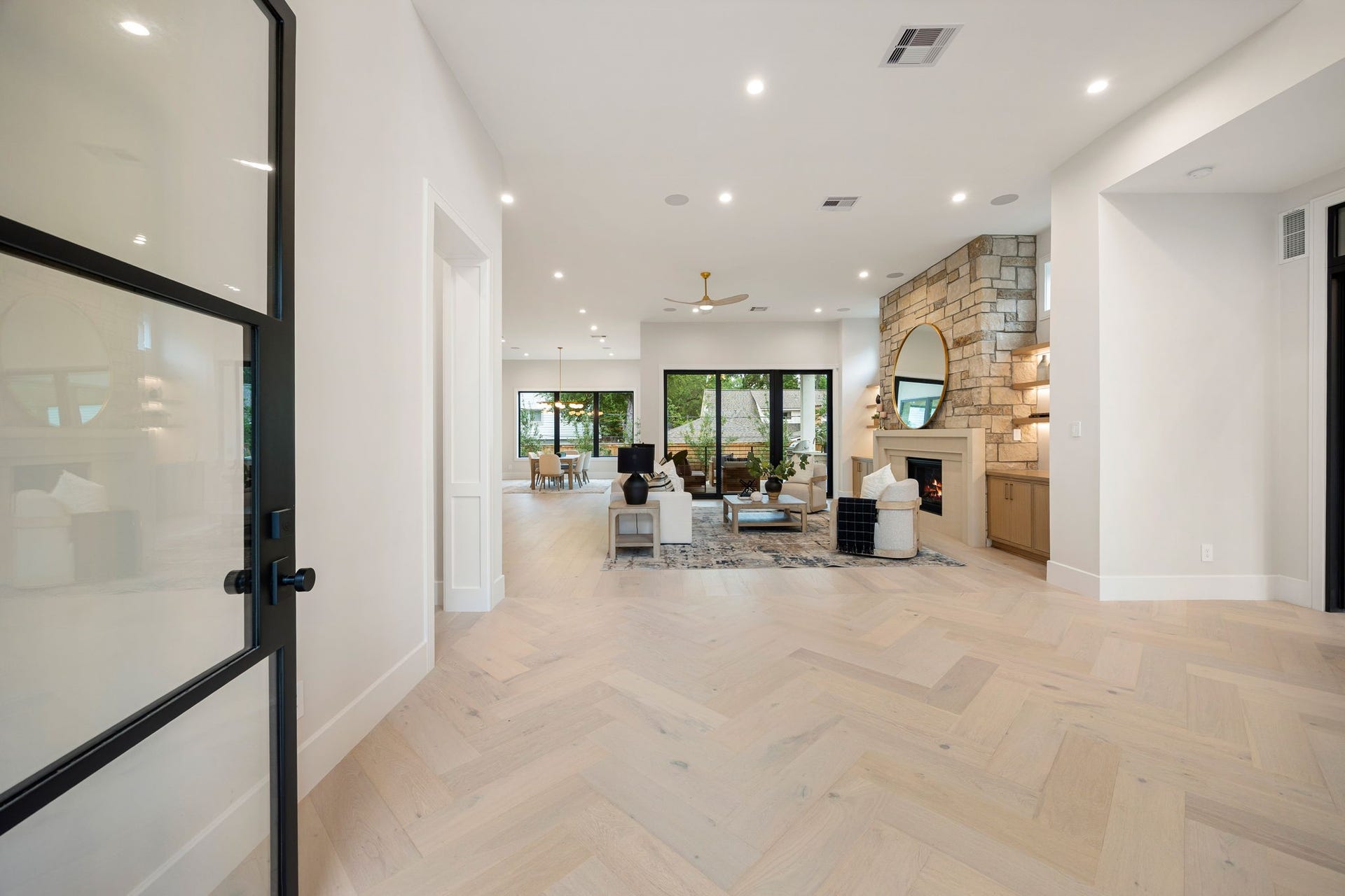 14106 Heatherfield Drive, Houston, TX 77079 An expansive living and dining area designed for effortless gathering, where natural light floods through large sliding glass doors that open to the outdoor living space. The open layout creates a seamless connection between indoors and out, while clean lines and soft, neutral finishes offer a timeless backdrop. Every detail feels intentional, creating a space thats both inviting and refined for everyday living or entertaining.