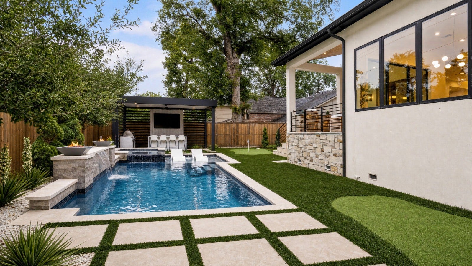 14106 Heatherfield Drive, Houston, TX 77079 Discover an extraordinary backyard retreat designed for relaxation and entertainment. This stunning outdoor oasis features a sparkling swimming pool with elegant waterfall features, dramatic fire bowls, and built-in lounge seating. Beautiful stone accents, lush landscaping, and a manicured lawn create a resort-inspired atmosphere. These photo have been virtually rendered for visual reference.
