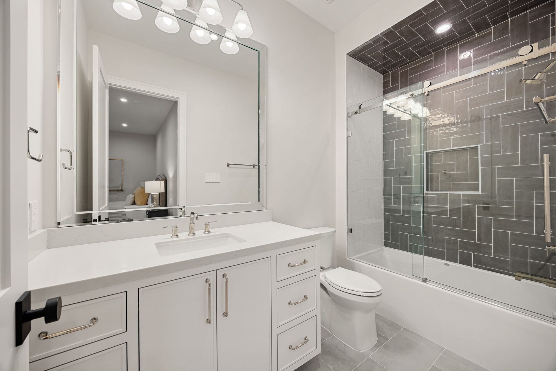 14106 Heatherfield Drive, Houston, TX 77079 This bathroom combines clean design with functional elegance, featuring a large vanity, ample storage, and bright lighting throughout. The neutral palette creates a timeless look that feels fresh and inviting. The highlight of this space is the tiled tub-shower combo with sleek glass enclosure and detailed tile work, offering both practicality and a polished, modern finish.