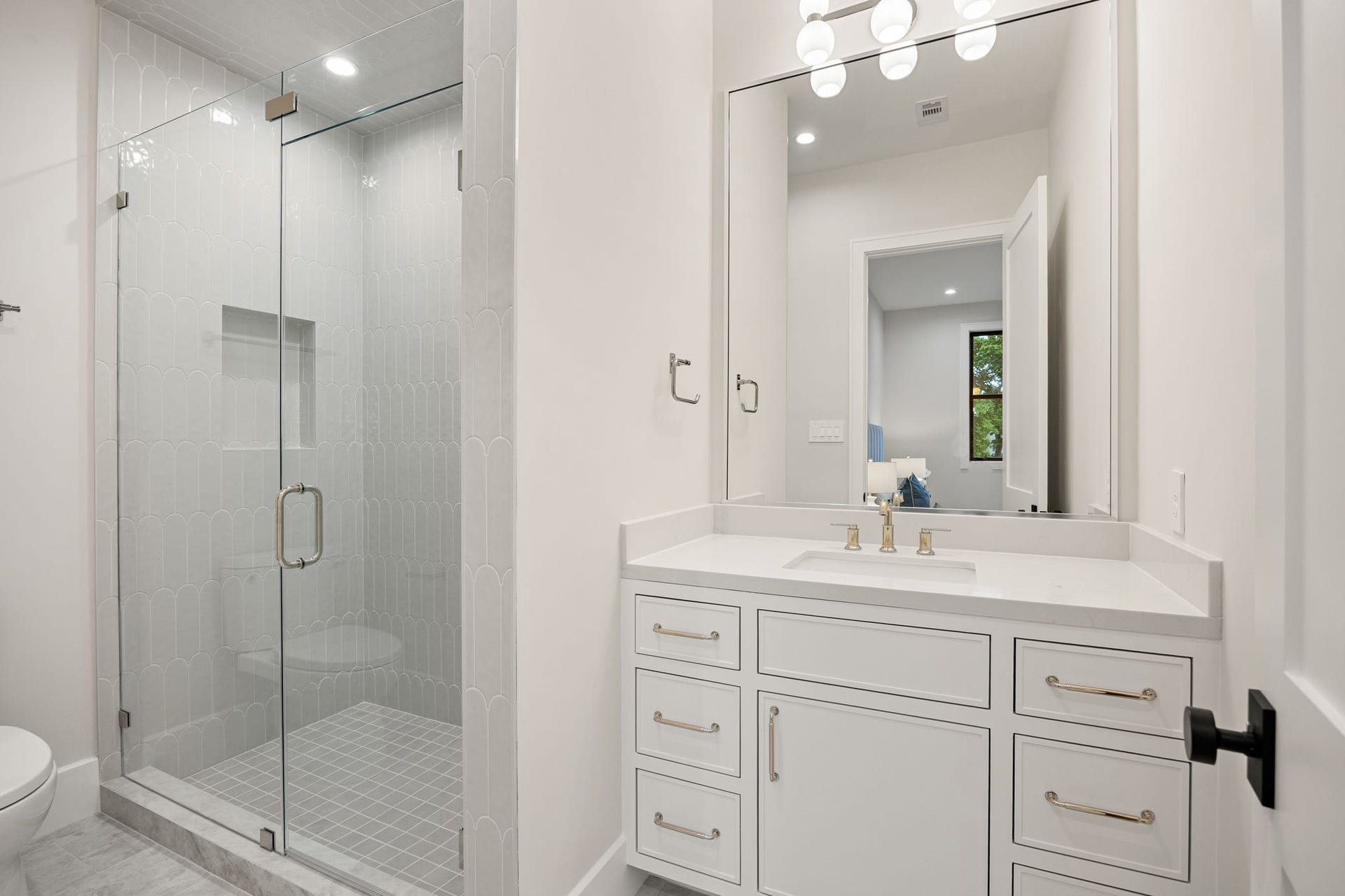 14106 Heatherfield Drive, Houston, TX 77079 This stylish bathroom showcases a clean and modern aesthetic, with a spacious vanity and elegant finishes throughout. Bright lighting and a neutral palette enhance the airy feel. The highlight of this room is the glass-enclosed walk-in shower with beautifully tiled walls, creating a spa-like experience that blends luxury with everyday functionality.