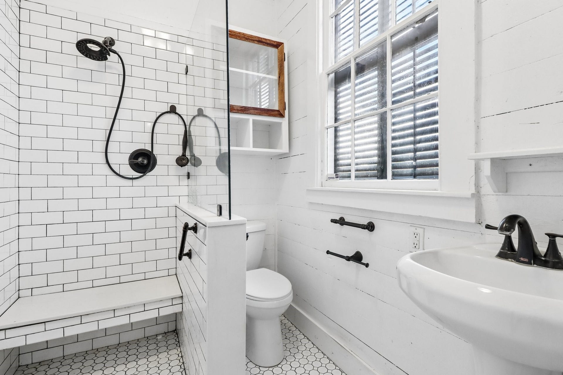 2318 Avenue M, Galveston, TX 77550 A bathroom with a freestanding clawfoot tub, pedestal sink and white finishes.