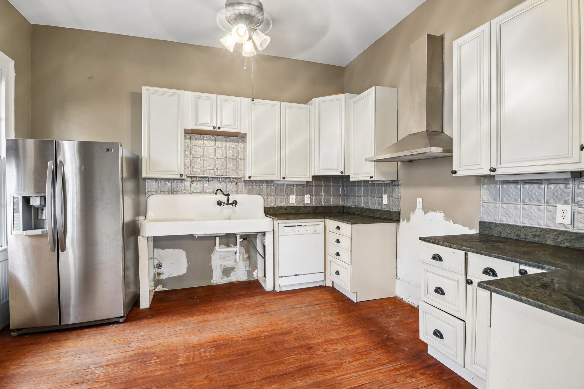 2318 Avenue M, Galveston, TX 77550 The kitchen pairs white cabinetry with dark countertops and windows that bring in natural light.