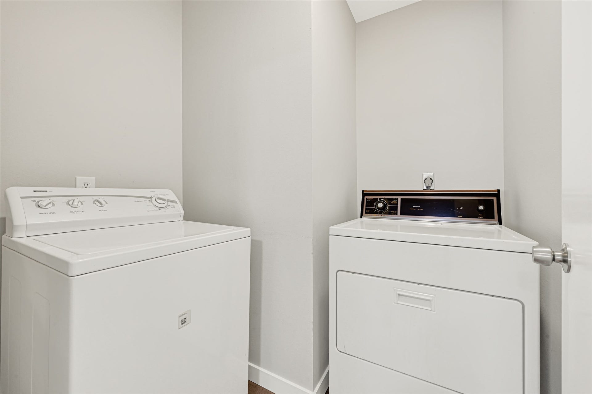 laundry room equipped with a washer and dryer, providing ample space for all your laundry needs and additional storage for cleaning supplies.