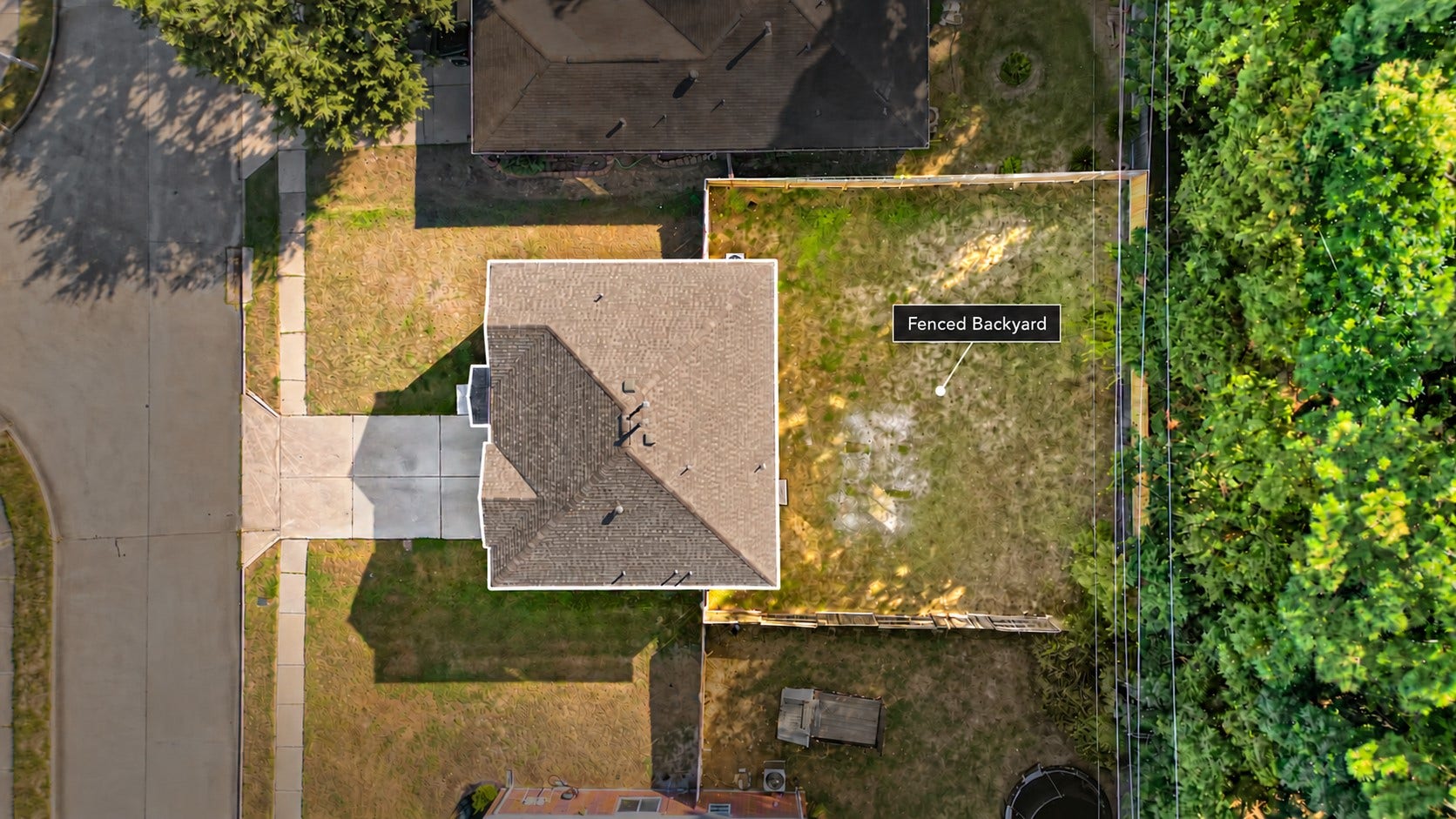 Aerial view showcasing the brand new roof and a spacious, fully fenced backyard.