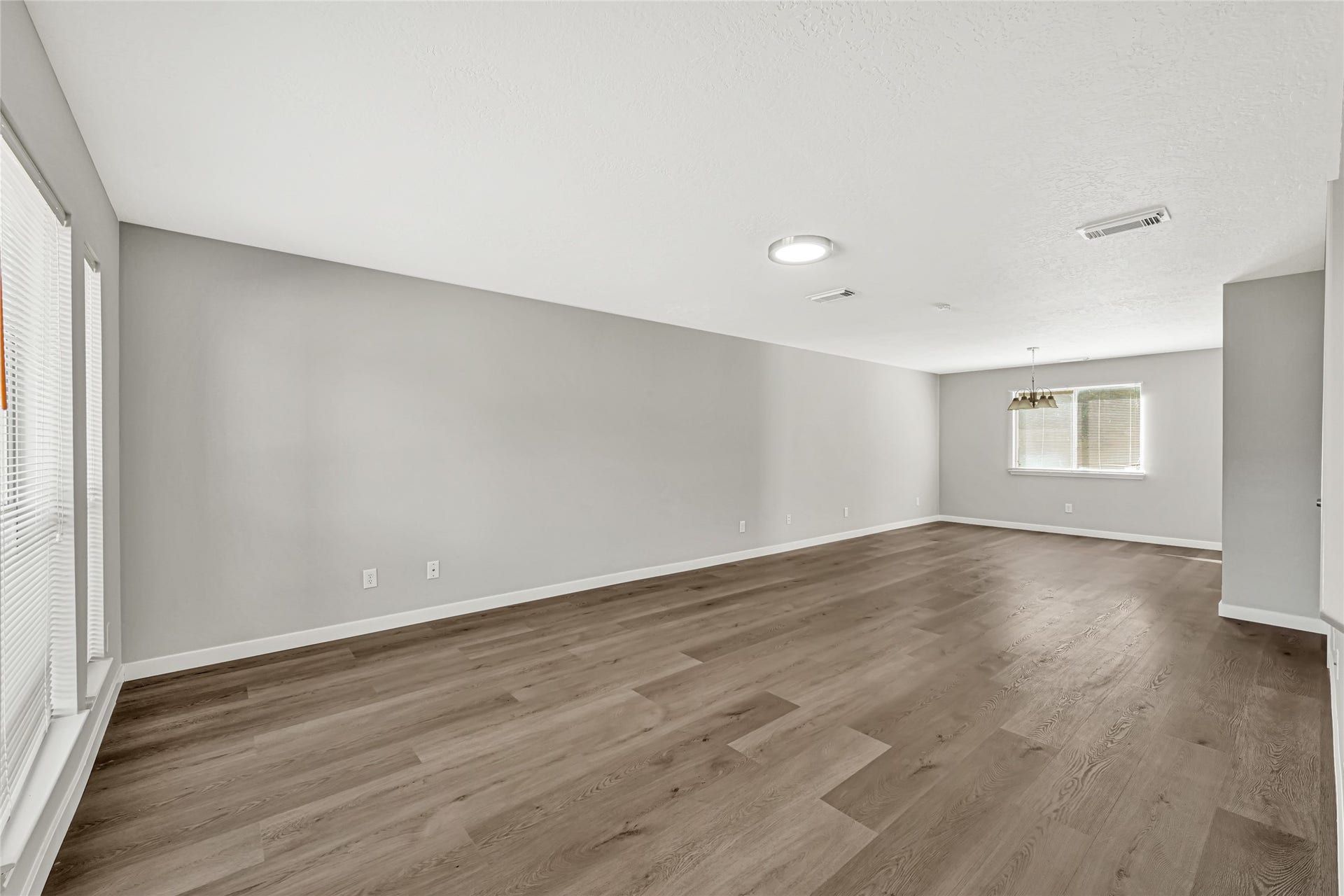 Expansive living area with beautiful brand new vinyl flooring