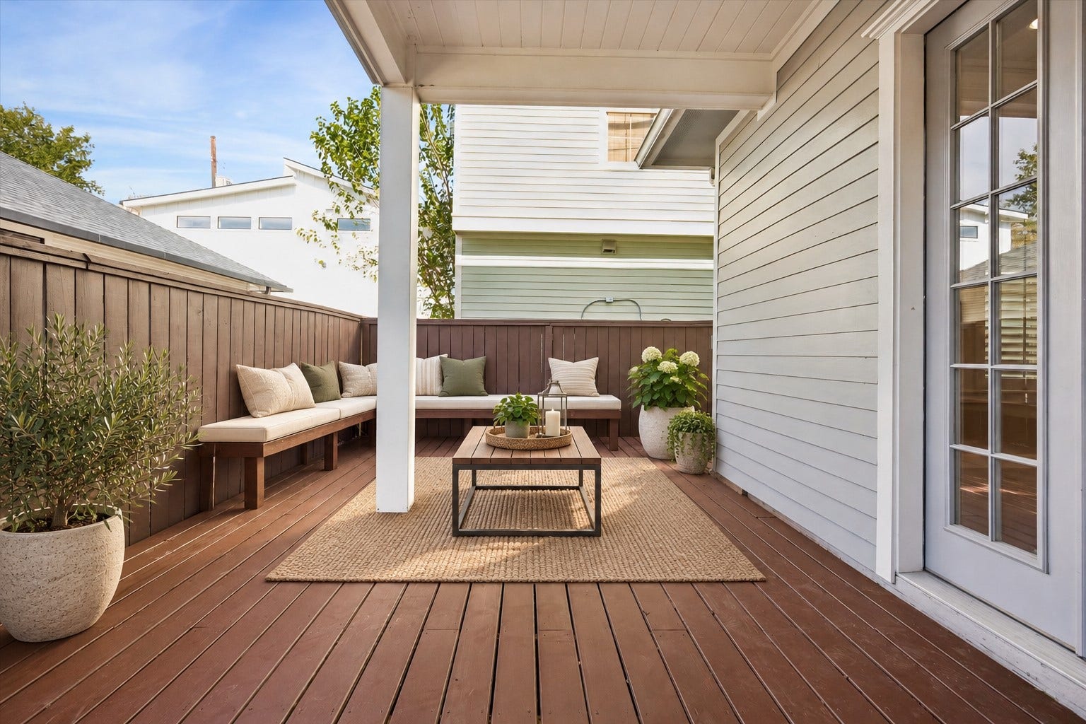 325 E 24th Street, #2, Houston, TX 77008 Private outdoor retreat offering a spacious wood deck with a partially covered seating area and privacy fencing, ideal for relaxing or gathering with guests. Photo is virtually staged.