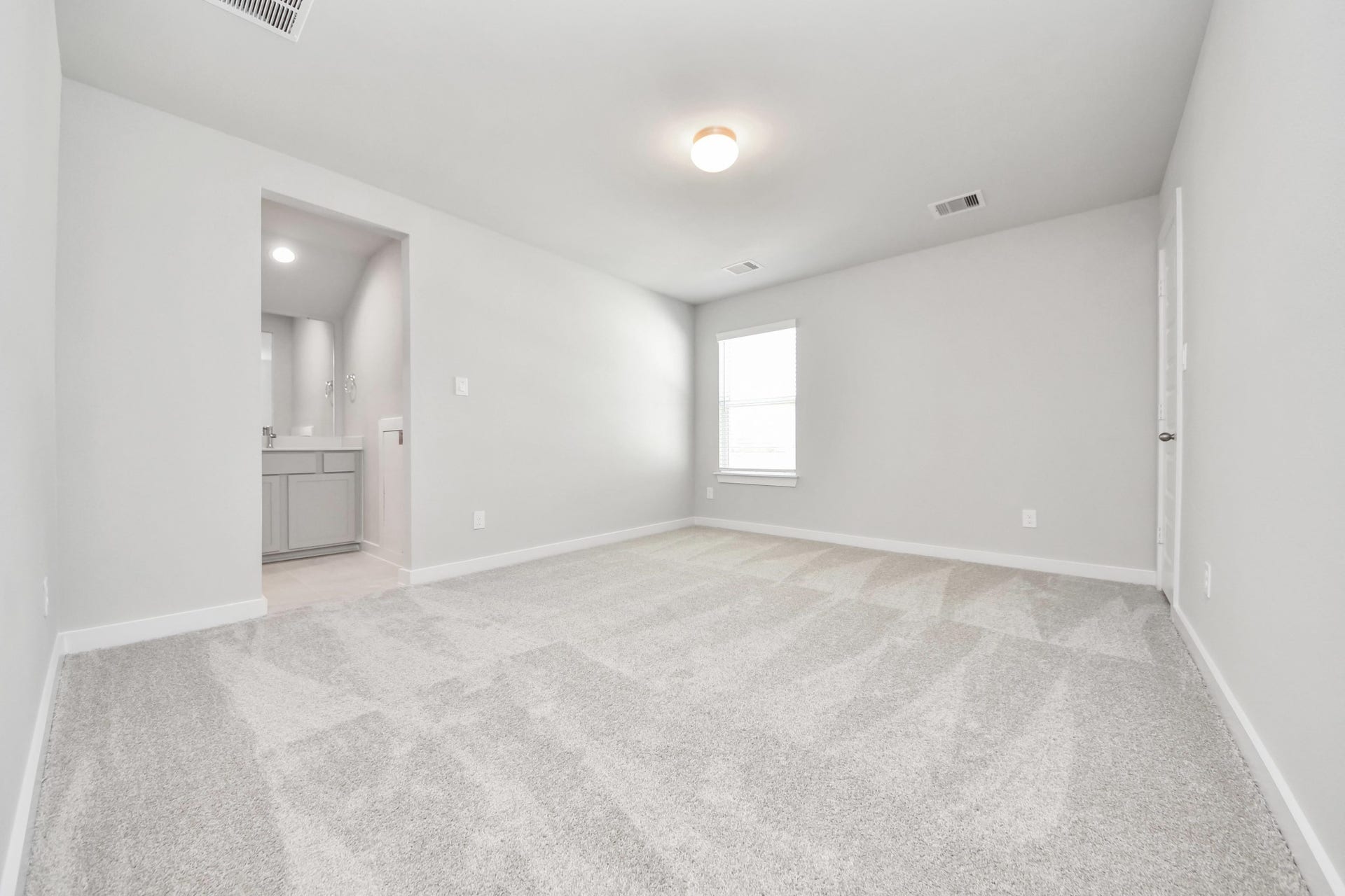 Secondary bedroom features plush carpeting, large windows that let in plenty of natural light, bright paint, and spacious closets. Sample photo of completed home with similar floor plan. Actual colors and selections may vary.