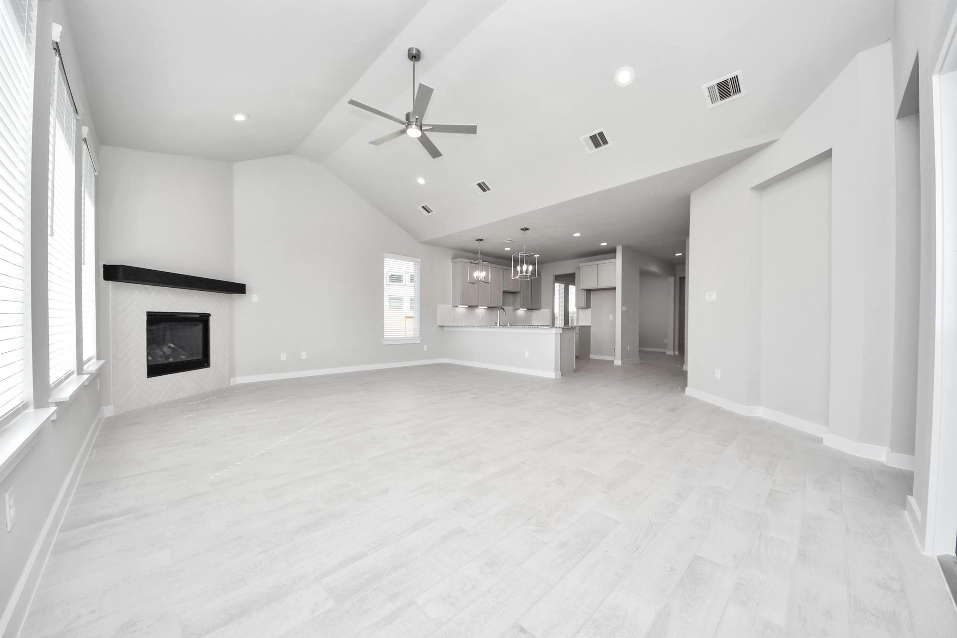 Relax and unwind in this inviting family room, illuminated by abundant natural light streaming in through tall windows, complemented by high ceilings and stunning flooring. Stay comfortable year-round with the gentle breeze from the ceiling fan, creating the perfect atmosphere for family gatherings. Sample photo of completed home with similar floor plan. Actual colors and selections may vary.