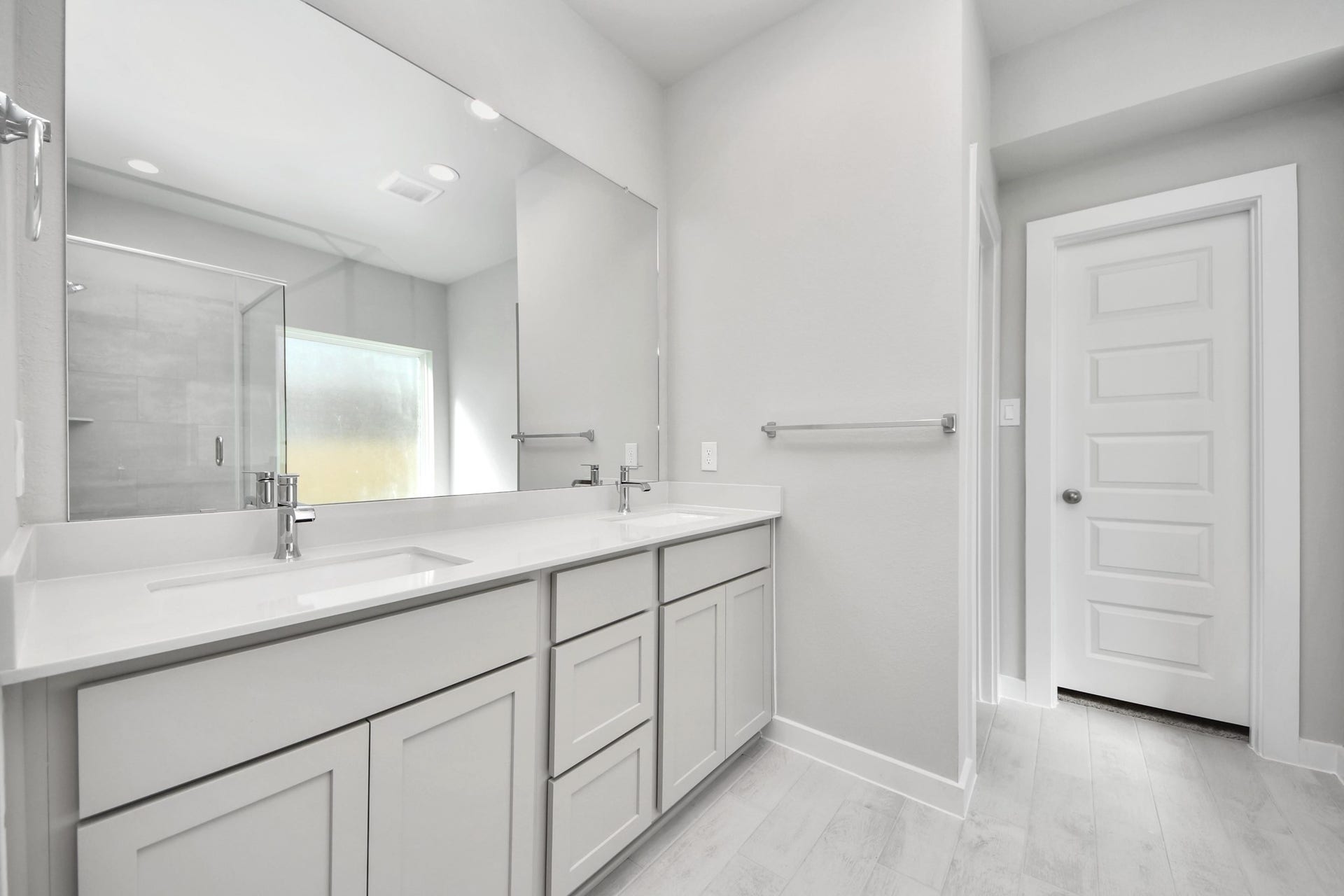 Escape to a spa-like oasis in this primary bathroom. Enjoy a walk-in shower with tile surround, a separate garden tub with custom detailing, and an elegant vanity featuring light countertops, modern hardware, and beautiful vanity lights. Experience luxury and relaxation in every detail. Sample photo of completed home with similar floor plan. Actual colors and selections may vary.