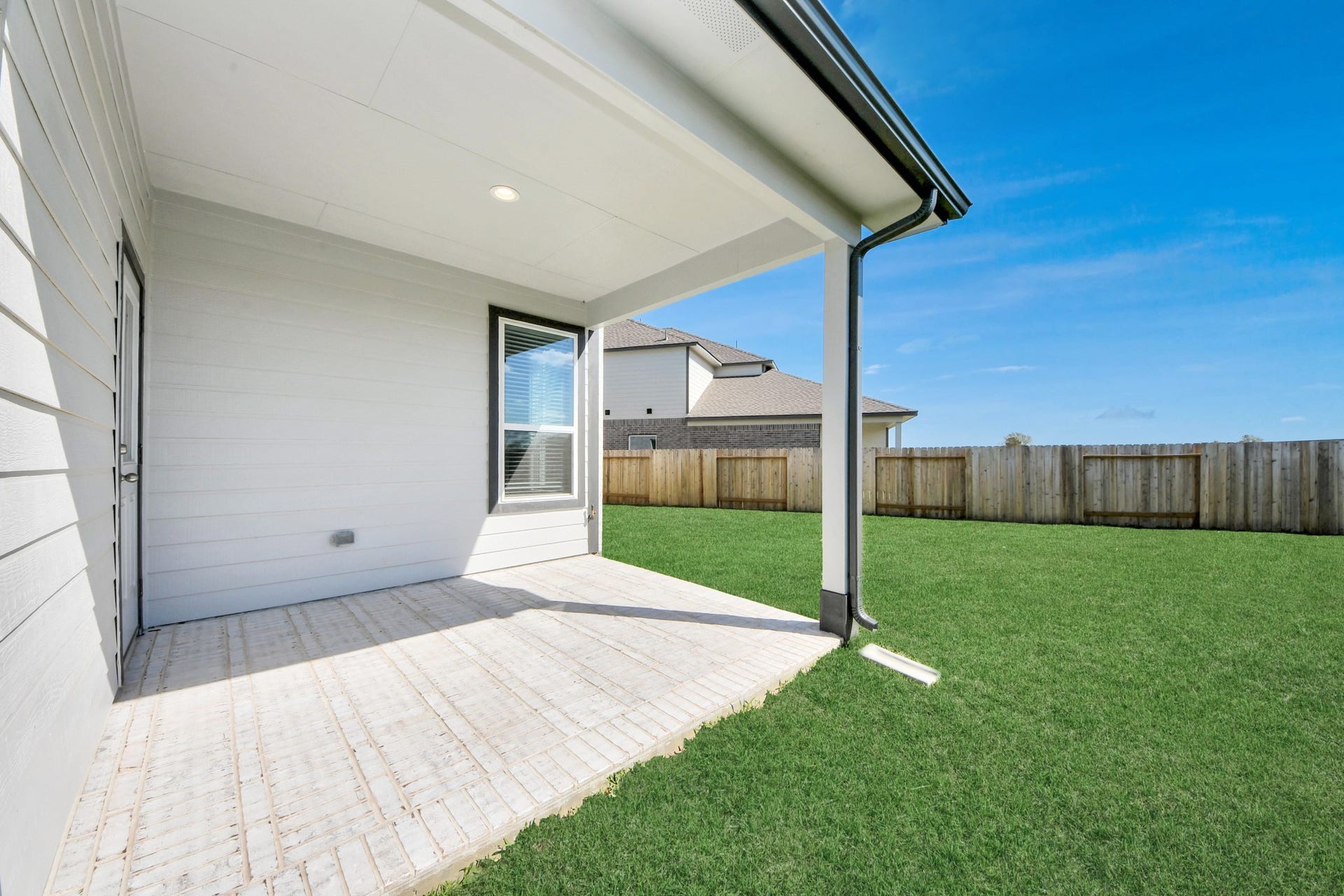 Experience outdoor living at its finest on this expansive covered patio, thoughtfully designed for BBQs and delightful outdoor dining. Sample photo of completed home with similar floor plan. Actual colors and selections may vary.