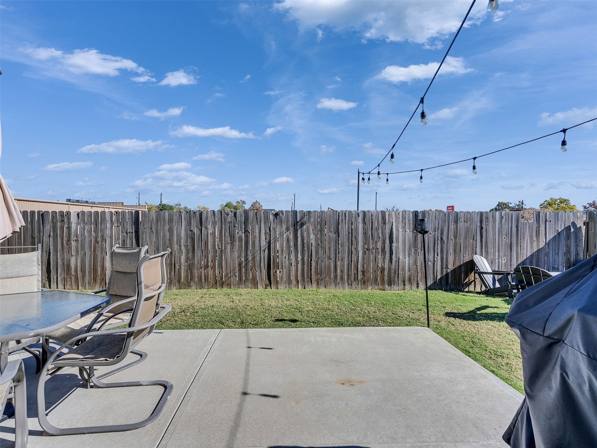 Expansive concrete patio perfect for weekend BBQs and outdoor lounging.