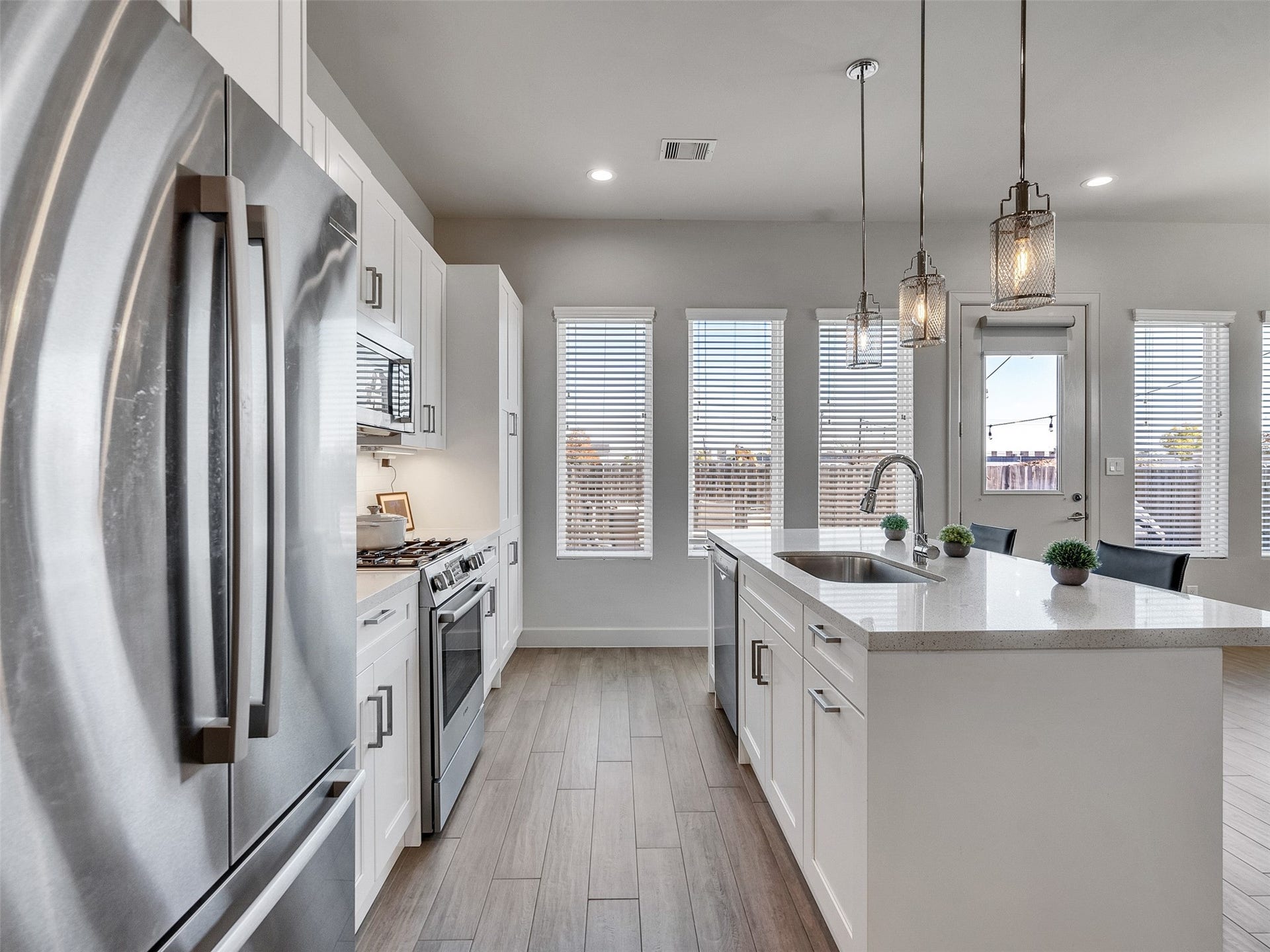 High-end stainless fridge and views overlooking the dining and living spaces.