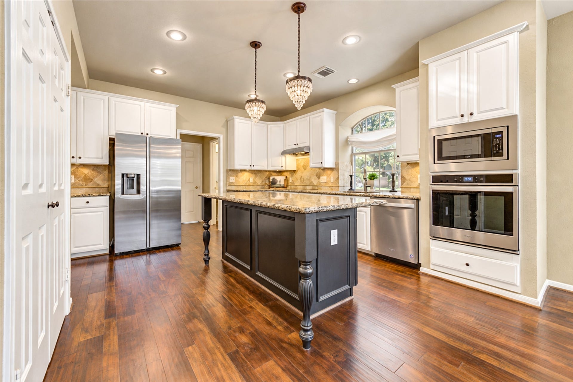 23338 Grand Springs Drive, Katy, TX 77494 The custom remodeled kitchen boasts a remodeled island with breakfast bar seating and on-trend light fixtures. Oven, microwave and dishwasher are approximately 3 years old.