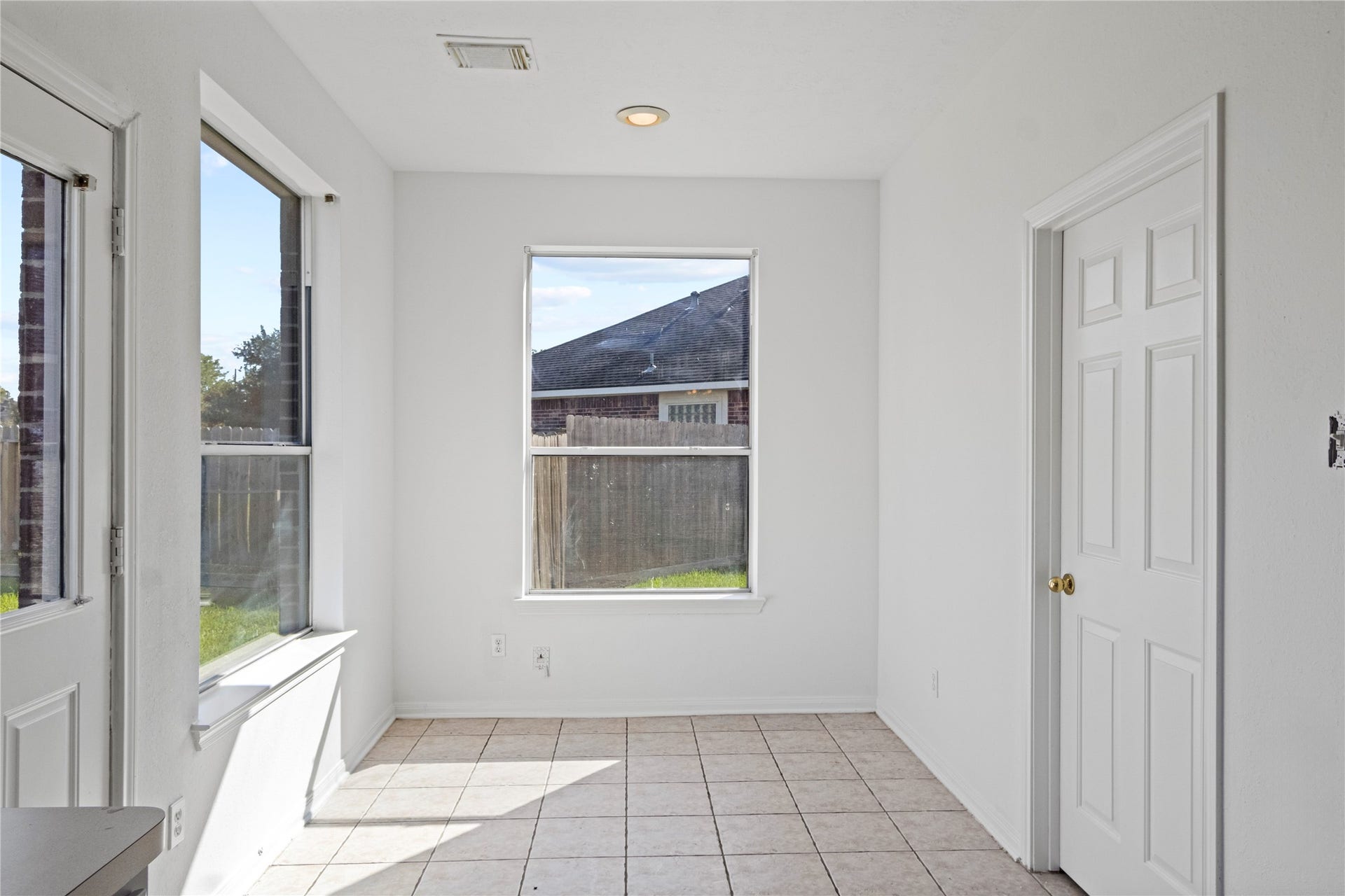 Bright breakfast area featuring abundant natural light, multiple windows, and tile flooring. Conveniently located just off the kitchen.