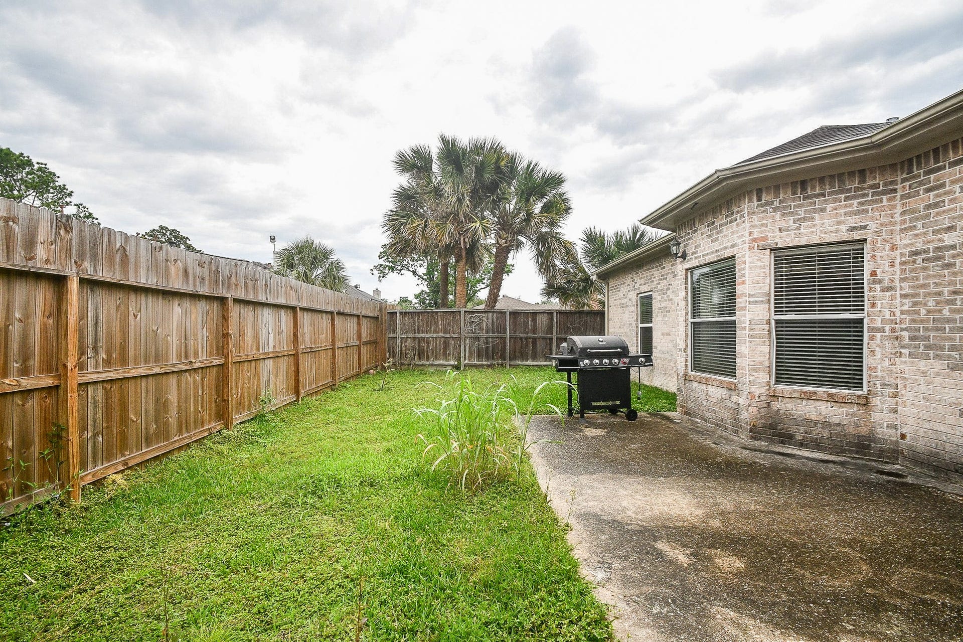 A private, fenced backyard featuring a cozy lawn.