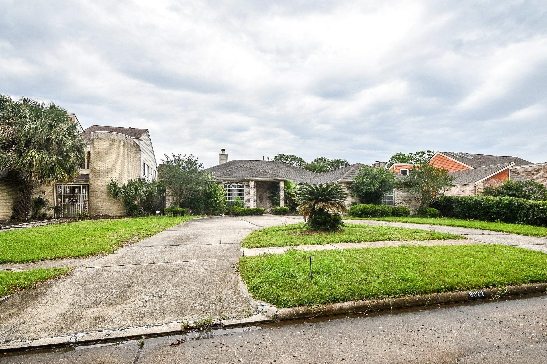 Stunning front yard with lush landscaping and mature palm trees.