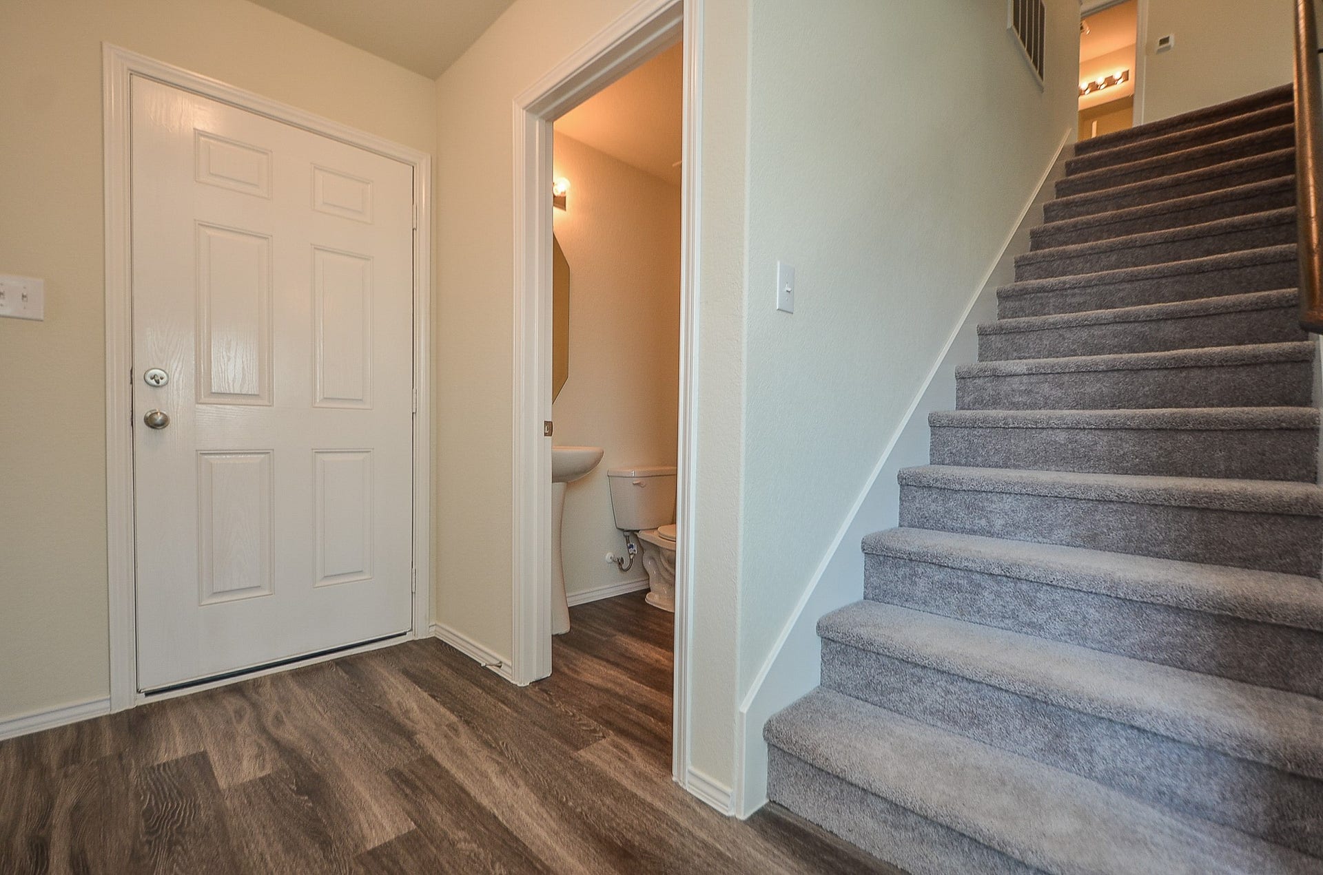 View of the half bath & stairs leading to upper level.
