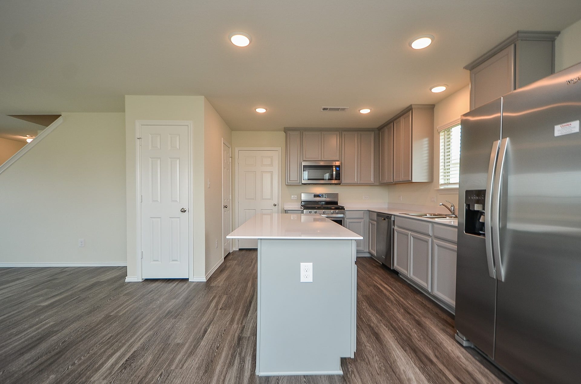 Timberlake Cabinetry w/ Birch Flat Panel Cabinets 30", uppers w/ crown molding, all in a sophisticated neutral gray palette. You'll have both a pantry & storage closet!