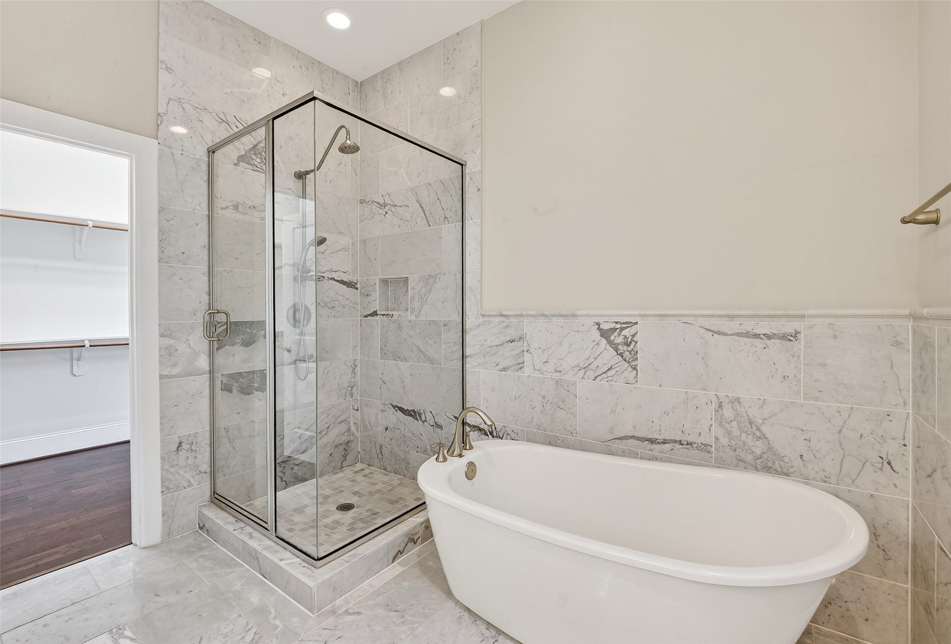816 Yale Street, #C, Houston, TX 77007 This bathroom features a sleek, modern design with a glass-enclosed shower and a luxurious freestanding bathtub, all set against elegant marble tile walls and floors.