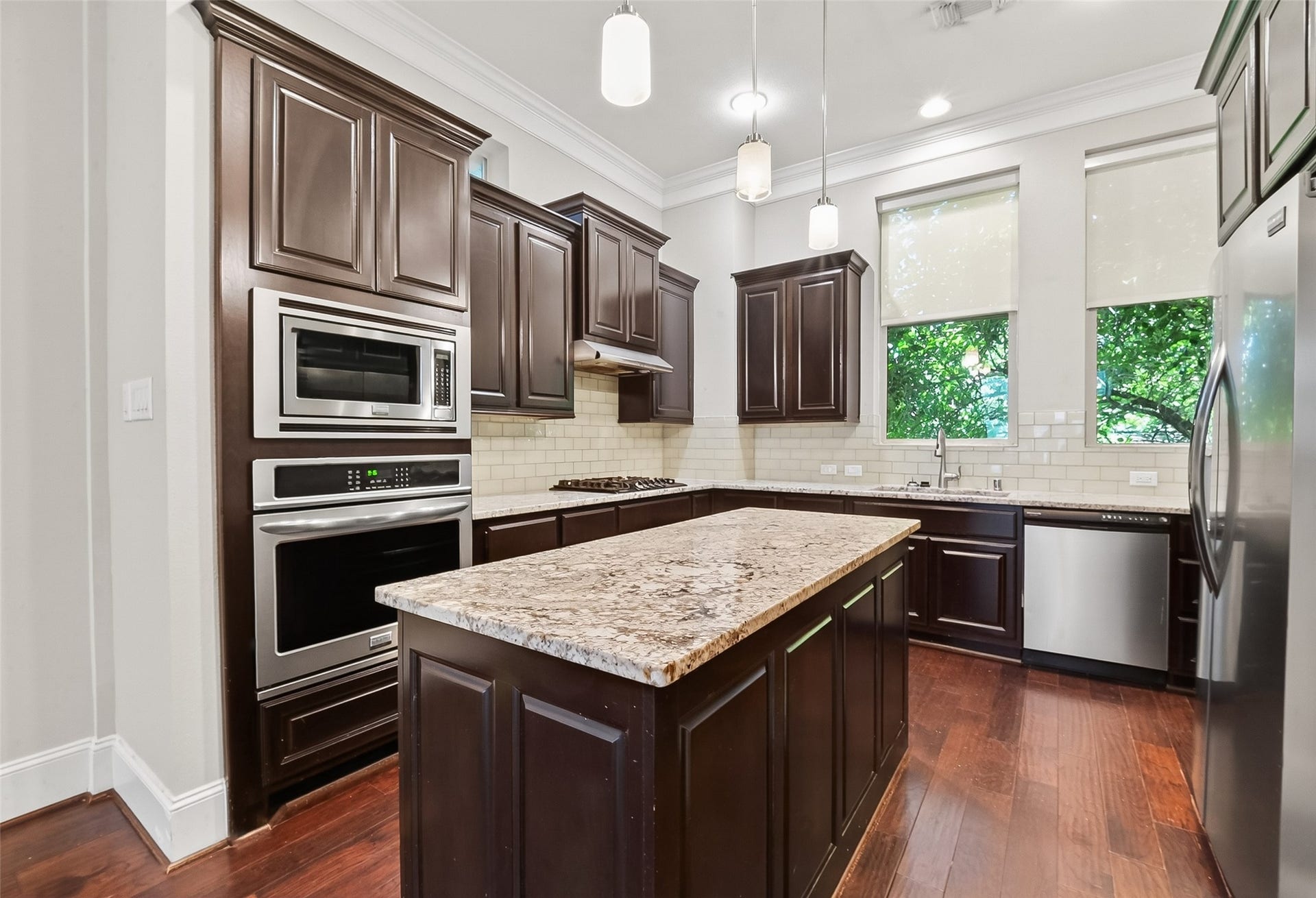 816 Yale Street, #C, Houston, TX 77007 The kitchen features elegant dark wood cabinets, granite countertops, and stainless steel appliances.