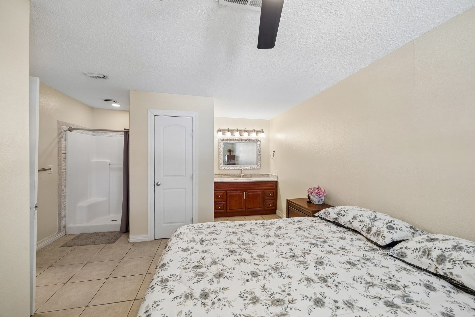 10702 Duncum Street, Houston, TX 77013 Cozy bedroom with an en-suite bathroom featuring a modern shower, elegant vanity, and ample natural light.