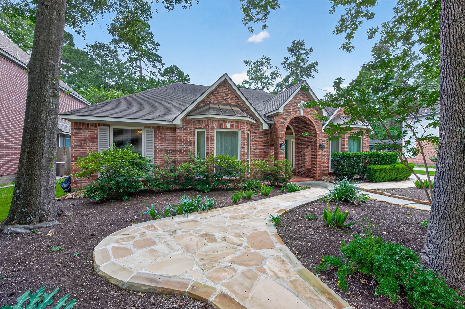 Timeless brick architecture, a
welcoming arched entryway, and
mature trees create exceptional curb
appeal from the moment you arrive.
Beautiful landscaping and a
charming stone walkway complete
the warm and inviting first
impression.
