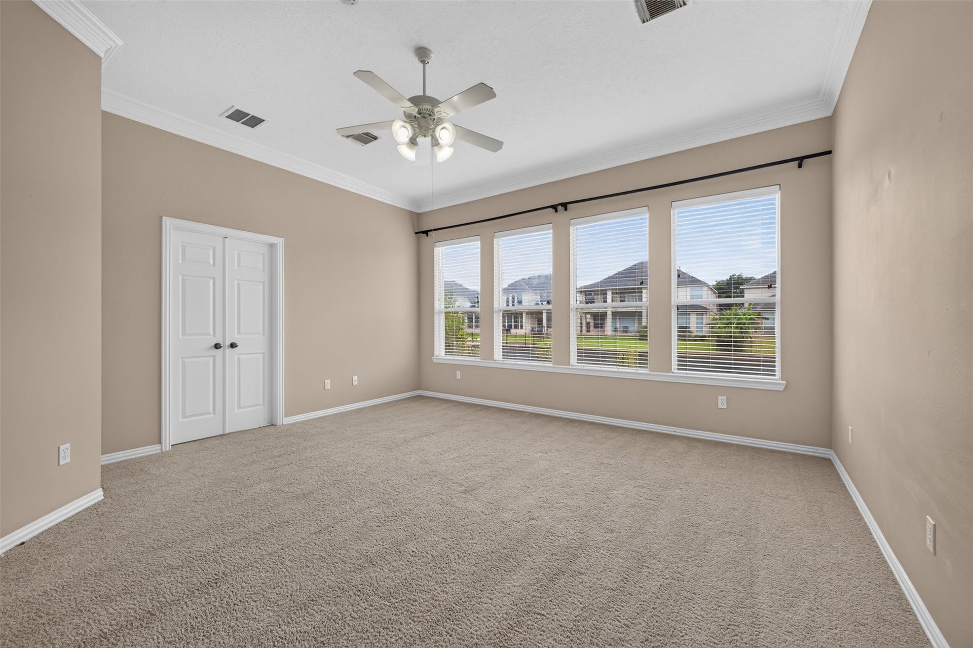 14326 Manorbier Lane, Sugar Land, TX 77498 This spacious bedroom features soft carpet, neutral walls, and large windows offering plenty of natural light and scenic views. It includes a ceiling fan for comfort and an ensuite bathroom for convenience.
