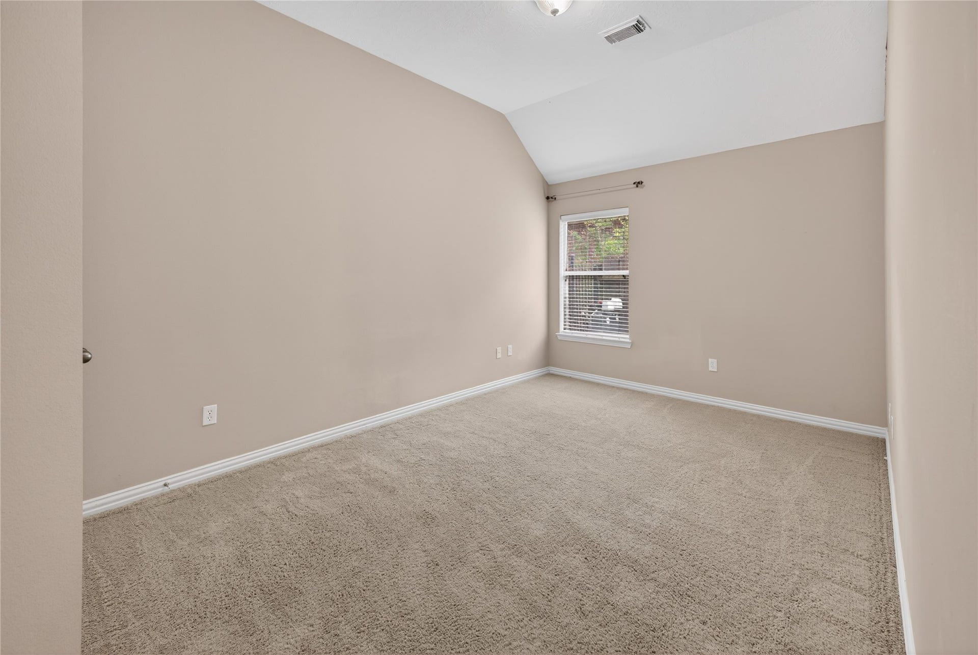 14326 Manorbier Lane, Sugar Land, TX 77498 This is a cozy, carpeted bedroom with neutral walls and a high ceiling. It features a single window offering natural light. Perfect for a guest room or office.