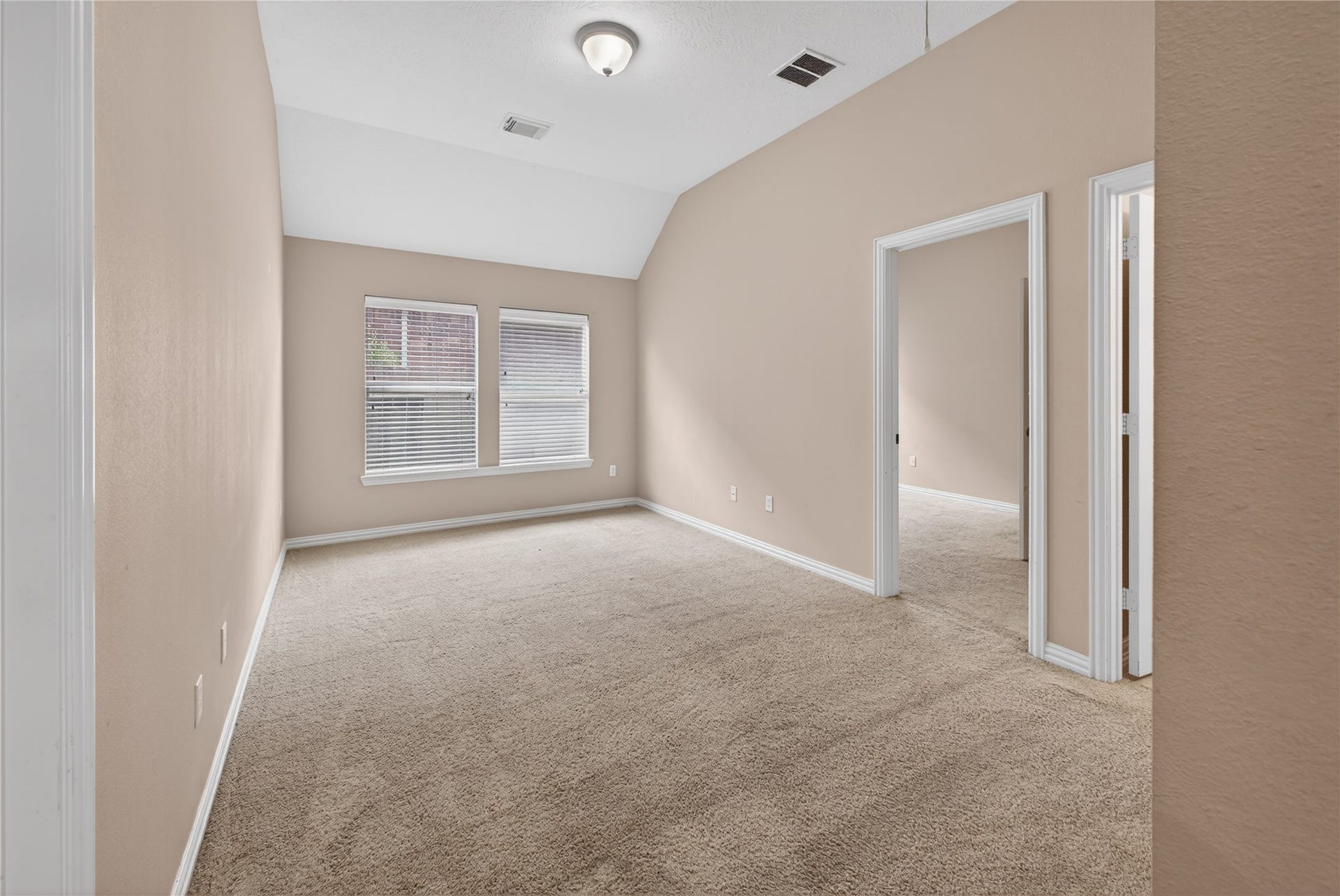 14326 Manorbier Lane, Sugar Land, TX 77498 This room features neutral-colored walls, carpeted flooring, and two windows providing natural light. It includes a ceiling light fixture and a doorway leading to another room, ideal for a bedroom or office.