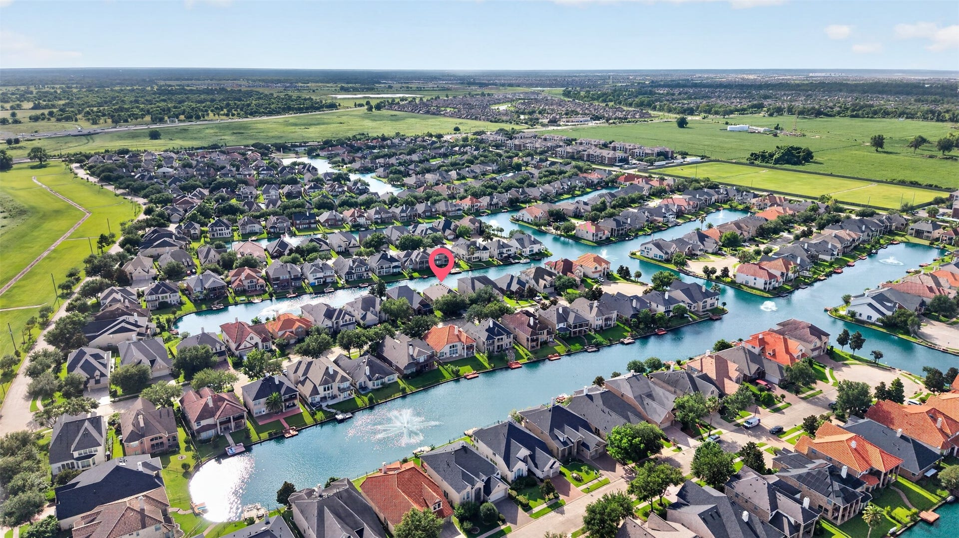 14326 Manorbier Lane, Sugar Land, TX 77498 This aerial photo showcases a picturesque, waterside neighborhood featuring well-maintained homes along a series of canals. The area is lush with greenery and offers a serene, suburban setting with easy access to green spaces.