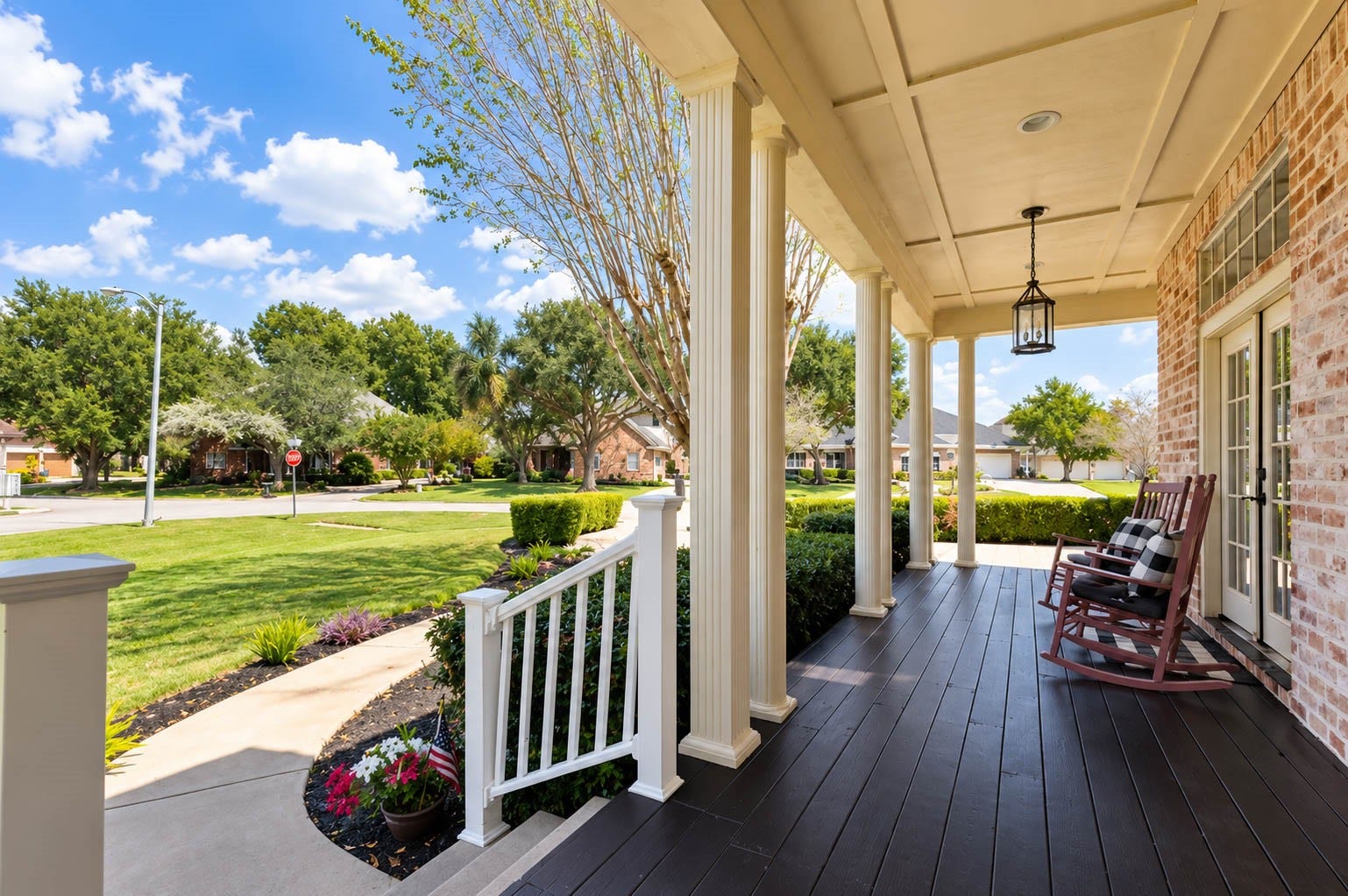 33103 Whickham Circle, Fulshear, TX 77441 The expansive covered front porch stretches gracefully across the home and wraps around to connect with the porte-cochre. Stately columns, rich plank flooring, & timeless architectural details create an inviting outdoor space with signature Southern charm.
